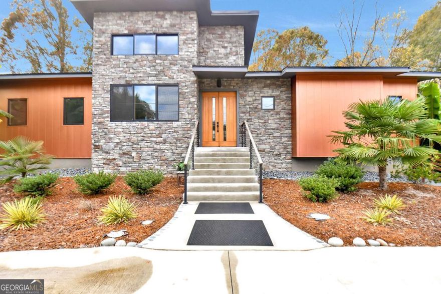 This Modern Southwestern Gem in Oconee County is one-of-a-kind! This  eye-catching home blends modern design with southwestern charm. The  gorgeous stone exterior is complimented by Arizona steel that transforms as the  sunlight hits it - a true showstopper! Beautifully landscaped with hearty banana  trees and palm trees, this home has all the curb appeal. Inside, you will find  2,200sqft comprising 2 spacious bedrooms, 2 full bathrooms, a powder room, an  office space, plus a full basement with endless potential. This homes expert  craftsmanship is showcased with high-quality white oak floors, designer fixtures,  and high-end tile work. Both bedrooms offer spacious and accessible closets. In  the master bathroom, you will find a deep soaking tub with a separate indulgent  shower for the ultimate spa experience! High-end ductless heating and cooling  systems can be controlled room for room. Enjoy natural light throughout! The  garage features tall, oversized garage doors that on one side is large and deep  enough to accommodate an RV or boat!  A full finished basement provides  endless opportunity - it is an excellent space for a workshop, storage, or further  expansion. Outdoor living shines with two screened porches connected to an  open central deck, perfect for grilling here - and entertaining. As a bonus, both  bedrooms have doors to their own porch. Exterior stairs lead to a lovely yard with  wooded acreage - a gardeners dream! A circular driveway offers extra parking  for all your guests. Top-of-the-line steel roof has a 5-year transferable warranty.  Rain always sounds better on a steel roof! This is truly a one-of-a-kind Oconee  County find - modern, warm, and designed to impress! You must experience it in  person!