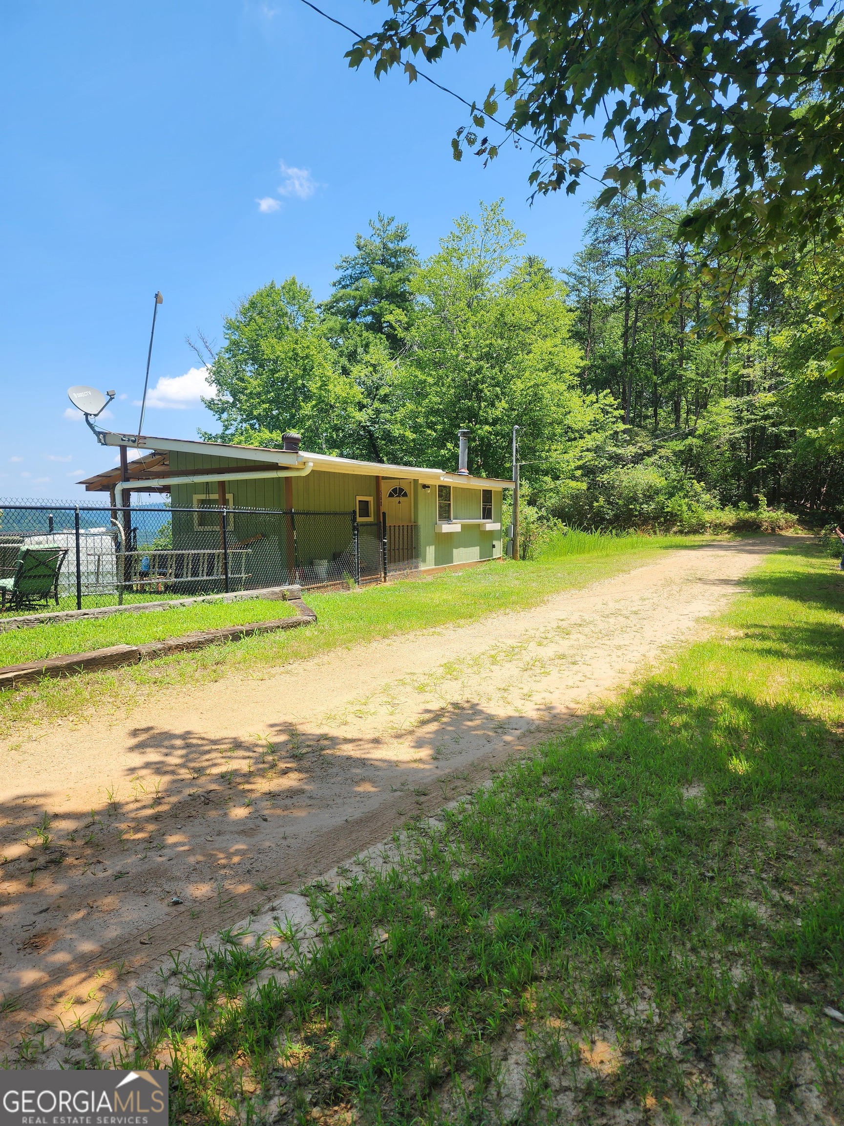 Hunting/fishing cabin in the beautiful mountains of Toccoa, surrounded by National Forest. This cabin features one bedroom off the kitchen area along with another bed in the studio style living room. In the living room you have a built in entertainment center, beautiful wood ceilings and big windows to enjoy your mountain views. Outside you will find a huge deck perfect for enjoying your morning coffee and sunrises, entertaining or even hunting. This property does have a separate building with a compositing toilet system. Bring your 4x4 vehicle to access this property in inclement weather. On those gorgeous days bring your boat and take advantage of the public boat ramp less than 1 mile away and fish for trout, walleye and more or fish Panther Creek (known for its trout). You will not find this "off the grid" property on GPS, so call your realtor now and make an appointment to tour this unique opportunity.