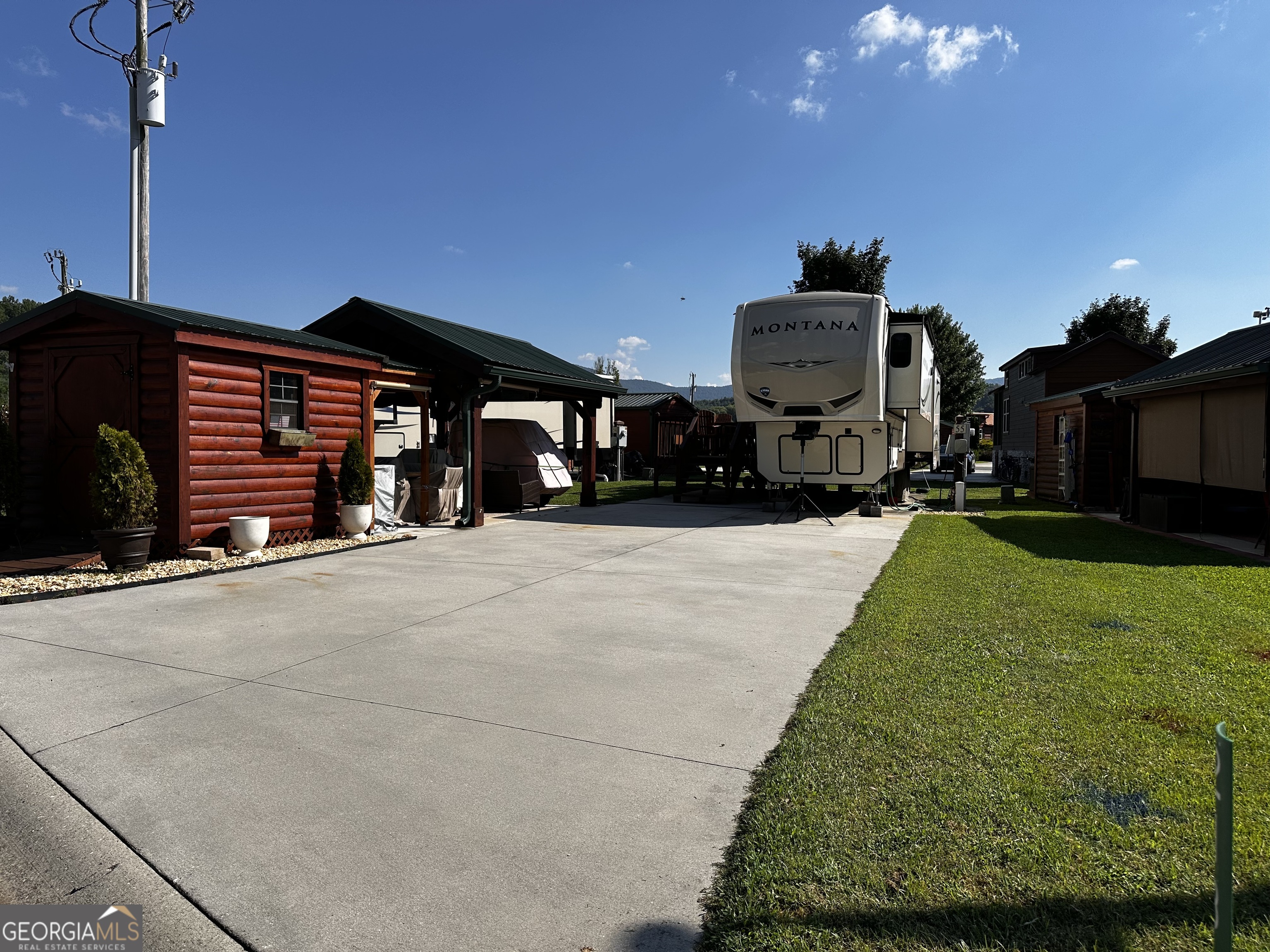 Nice back in lot conveniently located near the resort amenities! This is a complete package of RV lot and gently used 5th wheel. Pavilion with electric and TV. Large storage shed. Designated firepit area offers additional entertainment space. 2018 Montana Keystone 5th wheel - 3 slides, 1 bath, washer dryer, fireplace under tv, and so much more! Furnishings are included with this lot as well as a golf cart! This is a turn key property ready for you to immediately enjoy the cool mountain summer! A beautiful vacation lot, future or permanent residence. Add a cabin or use the fifth wheel! Crossing Creeks RV Resort and Spa welcomes class A,B and C RV's, as well as travel trailers and 5th Wheels!
