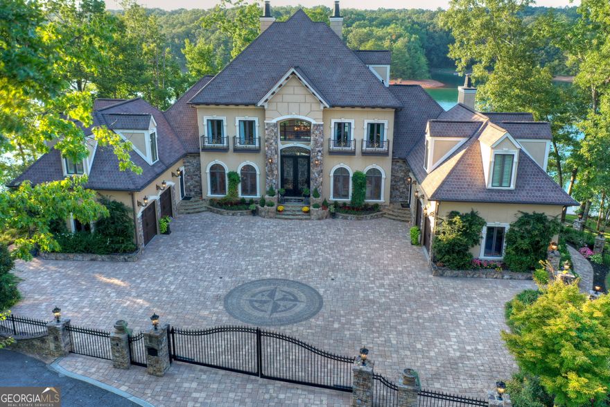 This magnificent property, situated on the shores of Lake Blue Ridge and just a short drive from downtown Blue Ridge, is a paradigm of luxury lakefront living. The home features 5 bedrooms and a bunk room, 5 full bathrooms and 3 half baths, all designed with a focus on sophisticated entertaining. The main floor boasts a formal living room, a dining room, an office space, and a gourmet kitchen complete with a breakfast area and keeping room. The master suite on this level includes a fireplace, a spa-inspired bathroom, custom tiled flooring, and a spacious walk-in closet. The second floor houses guest bedrooms each with its own private bath, a separate office and a library. The third floor is a haven for relaxation & socializing, featuring a custom bar, a comfortable lounge area, and a cozy fireplace. The terrace level is an entertainment paradise offering a billiard room, wine cellar, home theatre, exercise room, and additional sleeping quarters. The outdoor space is equally impressive with an outdoor kitchen & fireplace on the main level w/an additional outdoor fireplace on the terrace level complemented by a pool and hot tub for exceptional lakeside entertaining. Additional luxurious amenities include a custom boathouse, a four-car garage and elevator access to all levels of the home.