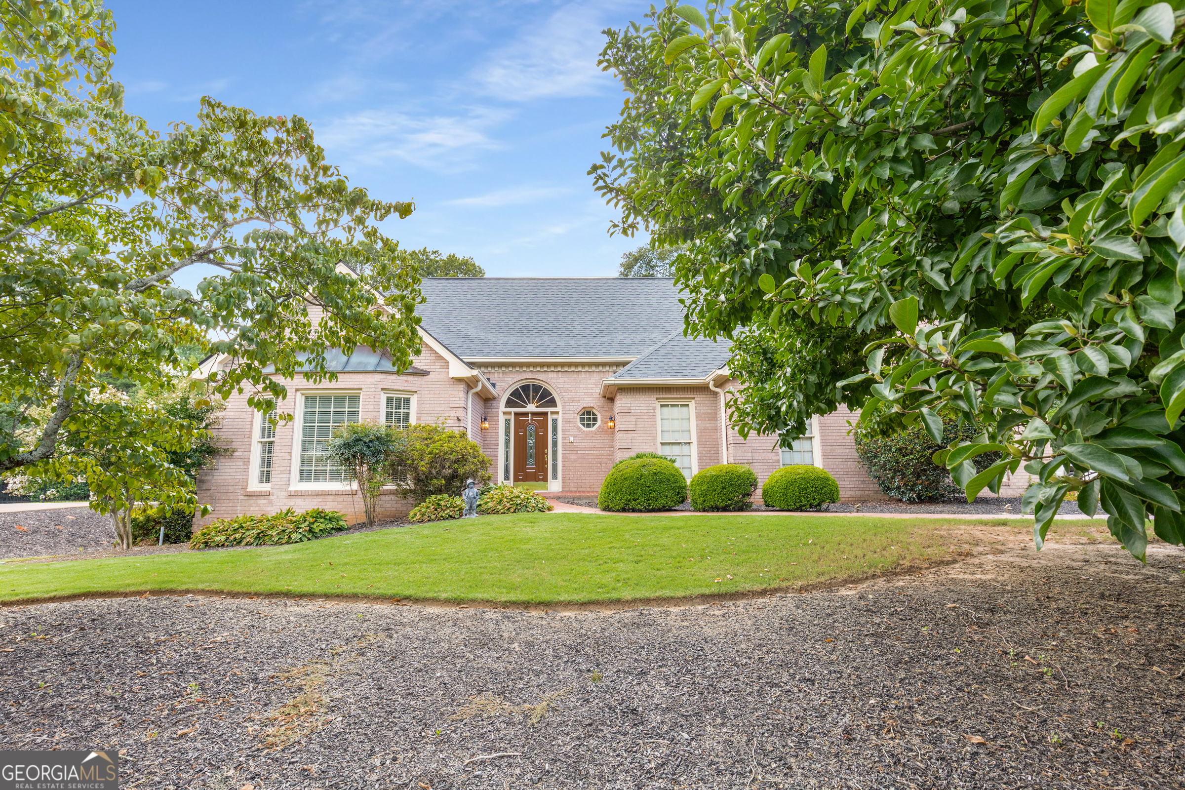 Nestled within the prestigious Polo Golf & Country Club community in Cumming, Georgia, this custom-built, 4-sided brick ranch on a full basement exudes timeless appeal. A majestic tulip tree greets you as you approach this meticulously maintained home, offered for the first time by its original owner and one of the initial residences in the Polo development. The expansive, level backyard is beautifully landscaped, presenting an ideal setting for a private pool oasis. Experience the unparalleled convenience of this prime location, where the golf course is visible from the driveway, the community pool parking is across the street, and the tennis and pickleball courts are just around the corner. Inside, discover site-finished hardwood floors and striking vaulted ceilings that enhance the open and airy ambiance. The kitchen, designed for seamless entertaining, offers ample space for gatherings. The oversized primary suite, situated on the main level, features a charming bay window and an elegant trey ceiling. The generously sized living room, anchored by a beautiful fireplace, flows effortlessly into the dining area. The upper level boasts two spacious bedrooms, a full bathroom, and expandable attic space, perfect for creating an additional room to suit your needs. Storage abounds throughout the home, with numerous closets and several dedicated storage rooms. A dedicated workroom, equipped with an extra-wide exterior door, allows for convenient storage of a riding lawn mower. The basement extends the living space, offering another comfortable gathering area complete with a fireplace. A large room currently utilized as an office provides the flexibility to serve as an additional bedroom, complemented by a full bathroom and a discreet storage area behind the door. This cherished, custom-built home is an extraordinary opportunity, ready for a new owner to infuse their personal style and create lasting memories. Polo Golf & Country Club is a family-friendly private club in Cumming. The community offers a championship golf course, adult and family swim centers, a tennis center with 10 lighted courts, and a vibrant social calendar. The club also includes a practice facility with a driving range, putting green, and chipping area. To be a member of the club is an additional fee. Polo is in the highly sought after Forsyth County Schools and is convenient to shopping ang Georgia 400.