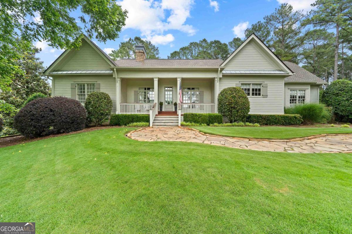 Tucked in the prestigious golf and lake community of Cuscowilla on Lake Oconee, 143 Wildwood Drive offers the perfect blend of privacy, luxury, and resort living. You'll feel as if you've stepped into the pages of a magazine in this exceptional 6 BR, 6.5 BA property offering lake views and designed for both grand entertaining and relaxed day-to-day living. The interior exudes the quintessential Cuscowilla warmth and elegance, featuring custom millwork, wide-plank hardwoods, wood beamed ceilings and high-end finishes throughout. The open layout flows from the living and dining areas into the chef's kitchen with the expansive island with seating and top of the line appliances. The entire space floods with natural light from oversized windows. The huge MBR offers beautiful lake views, coffered ceiling, tons of windows, and a luxurious bath with separate vanities. There are 2 additional BR suites on the main level, as well as half bath, huge butler's panty/mudroom with built-ins, and sunny laundry room. Upstairs is a wonderful flex space with built-ins ideal for hobbies or an additional office. On the terrace level you'll find 2 BR suites, large living room, office and workroom. Also an enclosed patio just off the pool area great for entertaining and storage. Above the 3 car garage is the poolside studio apartment complete with kitchenette, living area and full bath. This home is made for outdoor living! You'll love the well equipped outdoor kitchen, impressive stone fireplace, covered porch and open patios overlooking the pool and spa that are perfect for outdoor gatherings. The park-like private courtyard is another unique feature of this special property. Just a short stroll or golf cart ride from the shores of Lake Oconee, this stunning property is ideally positioned to enjoy everything this world-class community has to offer-from water sports and championship golf, to tennis/pickleball, to fine dining. Nearby, the towns of Eatonton, Greensboro and Madison offer charming shops, restaurants, and cultural attractions-all just over an hour from Atlanta. This property must be seen to be appreciated!
