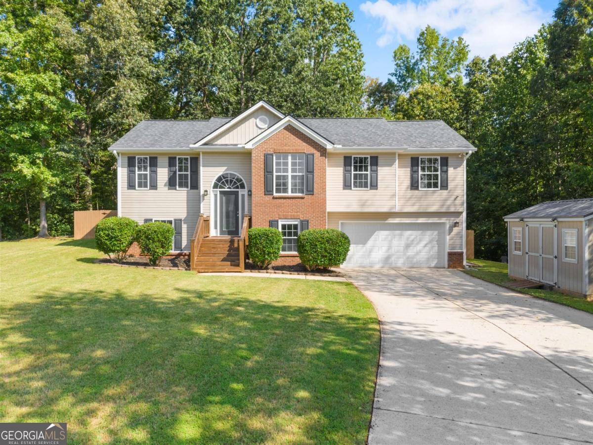 Welcome to this beautifully updated and expansive split-level home, perfectly nestled on a quiet, wooded cul-de-sac lot spanning over an acre in a non-HOA community! This move-in ready gem offers the ideal blend of space, comfort, and modern upgrades - inside and out. Step inside to discover fresh interior paint and brand-new flooring. The heart of the home features an open-concept eat-in kitchen with stainless steel appliances and flows seamlessly into the large, light-filled living room with vaulted ceilings, a cozy fireplace, and access to the oversized covered back deck overlooking your private backyard oasis. Formal dining room perfect for entertaining. Retreat to the spacious master suite featuring tray ceilings, plush new carpet, double vanities, separate shower and soaking tub, and updated vinyl flooring. Two additional bedrooms and another full bath complete the upstairs. The lower level offers incredible flexibility with a fourth bedroom, full bath, and a versatile bonus room or potential 5th bedroom - ideal for guests, a home office, or playroom. Plus, enjoy the convenience of a finished storage room behind the garage for all your extras. Additional highlights include: Newer roof, HVAC systems, and water heater. Septic tank pumped (August 2025). New gutters (2023). Comcast security system with 4 cameras, 2 keypads, motion sensor & door sensors - all included. Two larger storage buildings are included as well! With plenty of room to grow, entertain, or simply relax in nature, this Barrow County beauty checks every box. Schedule your tour today and make this home your own!