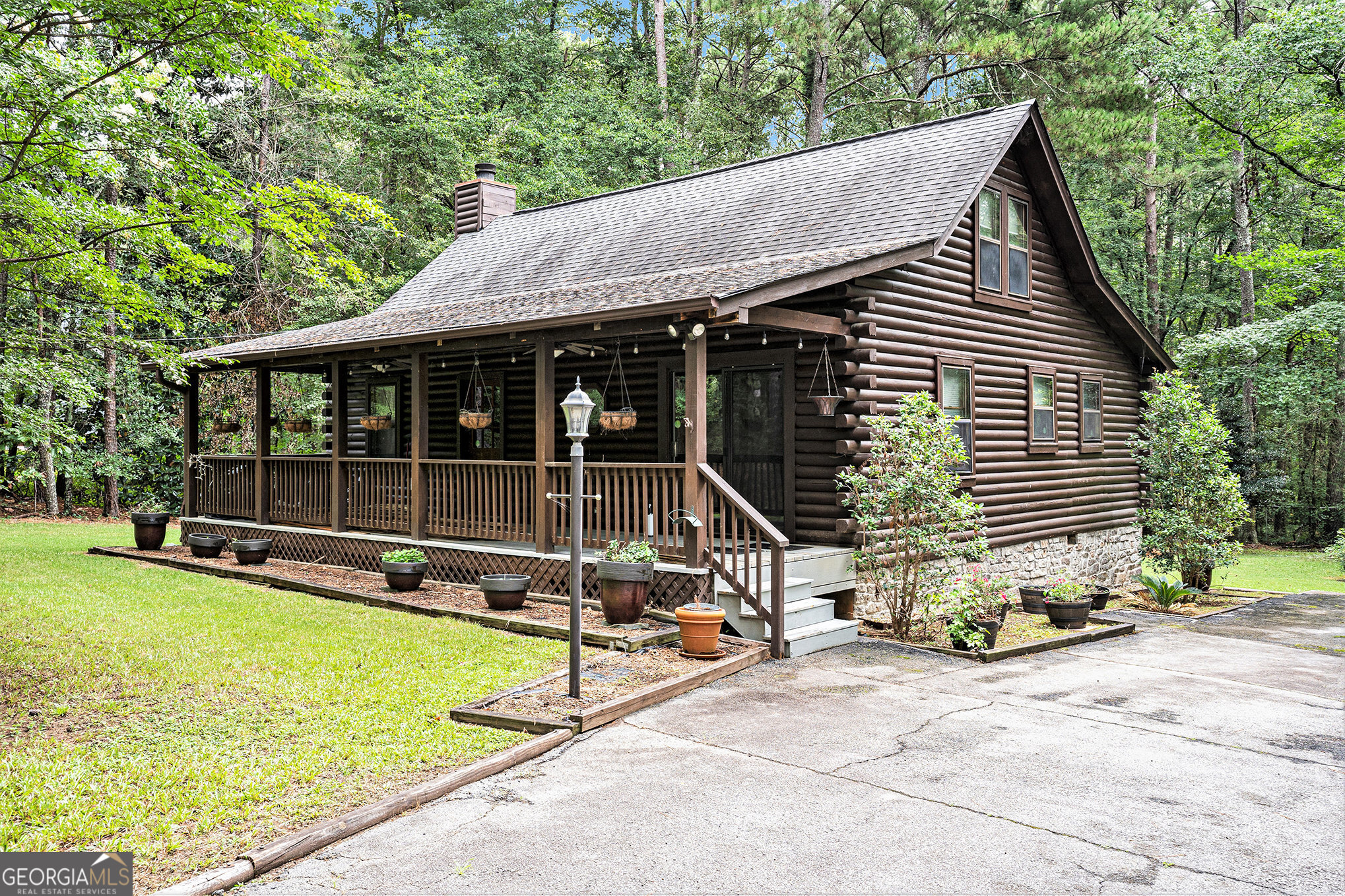 Charming log cabin nestled on a private 2.57-acre wooded lot in Conyers! This beautifully maintained 2BR/2BA home features a fresh-stained exterior, a newer roof (2022), and a cozy front porch perfect for relaxing. Step inside to vaulted ceilings with exposed beams, skylights, and a stone fireplace that anchors the living space. The bright sunroom offers flexibility as a home office, workout space, or potential 3rd bedroom. Enjoy a functional kitchen with all appliances included, along with a separate laundry room featuring washer and dryer. A detached 2-car garage provides extra storage and workshop potential. Enjoy the quiet of country living while being just minutes from shopping, dining, and I-20 access. Move-in ready with timeless rustic appeal don't miss this unique opportunity!
