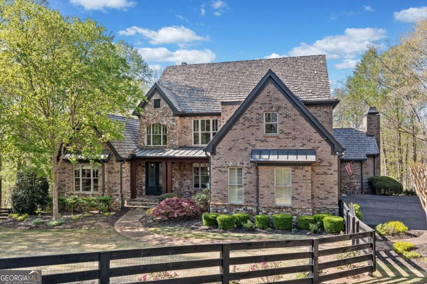 This private estate in Woodhaven Bend is on a charming almost 4-acre plot by the Etowah River. It's a unique find that combines nature with design. Beyond the gates, a winding drive leads to a custom-built home that showcases exceptional craftsmanship, comfort, and style, with rich millwork, six fireplaces, and coffered ceilings that evoke timeless elegance.    The kitchen, recently renovated, is a warm and inviting space perfect for both casual gatherings and gourmet cooking. It offers leathered countertops, custom cabinets, and premium appliances. These details flow effortlessly into a warm fireside keeping room and a light-filled breakfast nook. The main-level Primary Retreat is a serene oasis, complete with a spa-inspired bath and spacious walk-in closet.    Upstairs, three spacious ensuite bedrooms and a cozy loft provide ample space for guests or family. The terrace level is an entertainer's dream, featuring a media room, full bar, billiard space, a second spacious primary suite with an en suite bath perfect for guests or in-laws and a brand-new sleek home gym.    Outside, your own private resort awaits, featuring an outdoor kitchen with wood-burning fireplace, stone patio for relaxing, a PebbleTec saltwater pool, cascading stone waterfall, hot tub, and direct access from your backyard to miles of scenic trails and the Etowah River.    Woodhaven Bend residents enjoy exclusive access to community features. They can use a boat launch, relax in riverside pavilions, and explore 50 acres of preserved green space. This luxury retreat near Ball Ground offers privacy and convenience in a beautiful setting.    Marketed exclusively by Path & Post Real Estate. Where we think every extraordinary home tells a unique story.