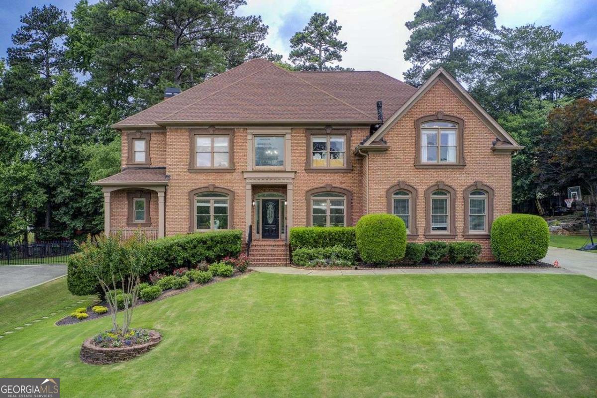 Sophisticated & Timeless renovation in the highly desirable Sugarloaf Springs community-just minutes from Sugarloaf Mills & I-85. Perfectly positioned on a private lot across from top-tier amenities, this elegant home offers a grand 2-story foyer, formal living & dining rooms, and a sun-drenched fireside family room. The showstopping gourmet kitchen boasts an oversized island, upgraded cabinetry, and premium stainless appliances. Main level includes an en-suite bedroom, stylish powder room, and spacious laundry with storage and utility sink. Upstairs features a lavish primary suite with fireplace, dual walk-in closets, spa-like bath with soaking tub, oversized shower, and dual vanities. Additional bedrooms include another en-suite and a shared double vanity bath. The terrace level offers a full in-law suite with kitchen, media room, and flexible living space. All major systems and roof are under 5 years old. Newly installed irrigation system and gutters. Move-in ready luxury!