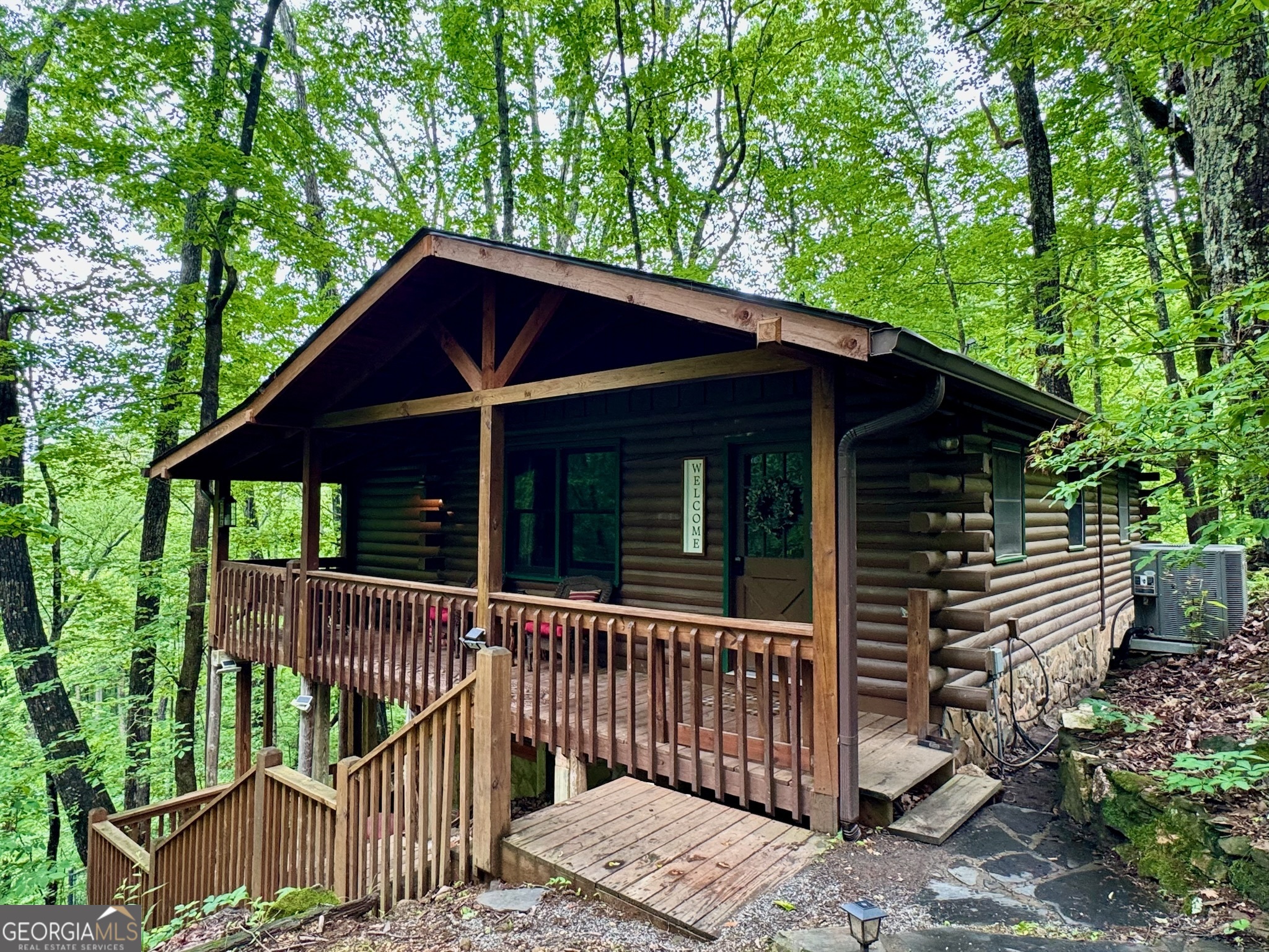 Relax and escape the hustle and bustle of everyday life to Grandpa's charming cabin. Just minutes from the sought-after mountain town of Blue Ridge, this location is hard to beat in the heart of Aska. A wonderful investment, whether you're considering part-time or full-time living, or as a rental investment. This nostalgic log cabin with old world charm is set among hardwoods, thru stone pillars and a stone wall at the end of the long driveway. A two level retreat with mostly wood interior, wood & tile floors throughout, 2 1/2 bedrooms, 2 bathrooms, kitchen, dining room and 2 separate living areas. Outdoors you will find a large deck, hot tub and firepit to spend your days and evenings listening to the peaceful flowing stream, roasting, toasting, & enjoying the mountains! Property has several outbuildings and levels to accommodate your vision of the perfect mountain getaway. Hiking trails, kayaking, fishing the Toccoa River, and beautiful Lake Blue Ridge are just a few minutes away. Not currently in rental, but can be set up for immediate turn-key rental income! Sold As-Is.