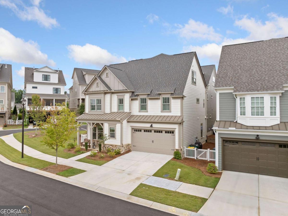OPEN HOUSE 7/19 2:00pm-4:00pm / $10k SELLER CONCESSIONS with acceptable offer. Run to this immaculate and better than new 5-bedroom, 4-bathroom Paired home located in the highly desirable South on Main community just steps from vibrant Downtown Woodstock. All the upgrades are included as this home offers modern elegance and functionality with White Oak hardwood floors throughout the main level, an open-concept living area featuring a cozy fireplace with built-ins, and a screened, covered side porch perfect for relaxing or entertaining. The gourmet kitchen is a chef's dream, showcasing a Custom Cafe Appliance Package, granite countertops, a large island, crushed granite sink, and ample cabinetry. A main-level bedroom and full bath provide convenience for guests or multi-generational living. Upstairs, the spacious primary suite is a private retreat with a soaking tub, double vanities, and his & her custom closets. Two additional bedrooms on this level offer flexibility for a home office, nursery, or workout space, with one featuring barn doors for added charm. A full laundry room with sink adds practicality. The third level includes a large media room pre-plumbed for a wet bar, along with a fifth bedroom and full bath, ideal for a guest suite or private quarters. The garage features custom built-in cabinets for plenty of storage as well as wired for an EV Charging Station. This home sits on a premium end lot with extra green space to enjoy. Practically maintenance free living as the HOA takes care of the exterior of the home as well as the roof and the landscaping. Enjoy all the amenities South on Main has to offer, including a resort-style pool, clubhouse, fitness center, community garden, playground, dog park, and direct access to the Noonday Creek Trail. Walk, bike, or ride your golf cart to everything Downtown Woodstock has to offer: shops, dining, live music, and community events. This move-in ready home combines location, luxury, and lifestyle-everything you've been searching for and more.