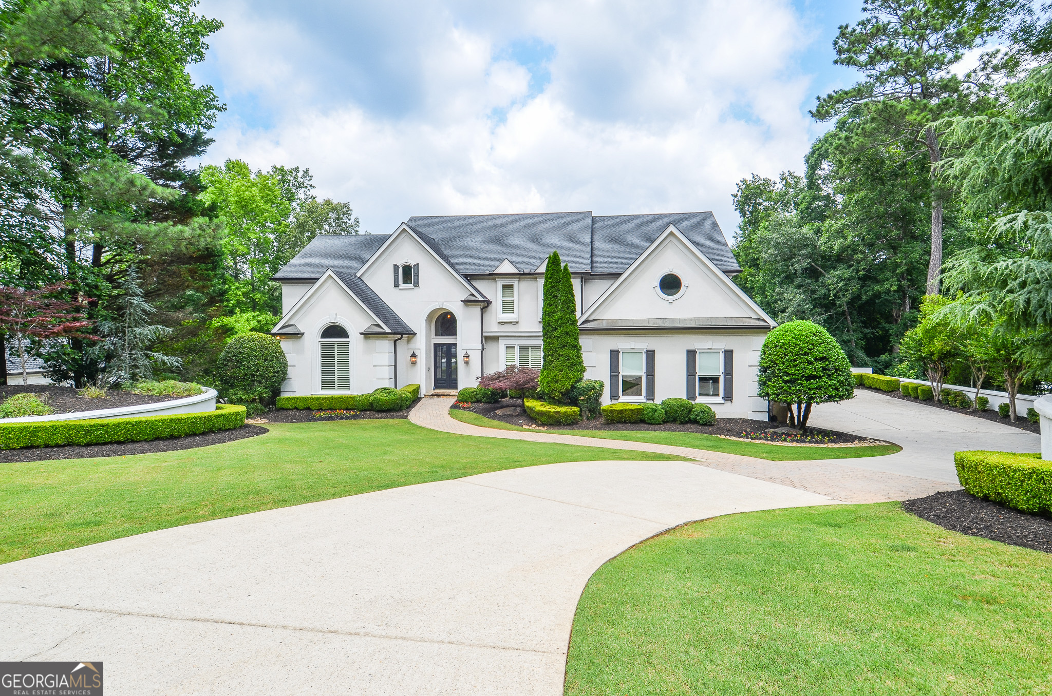 Elegant Estate Living in Prestigious Country Club of the South Welcome to 965 Tiverton Lane-an exquisitely renovated residence nestled within the exclusive, guard-gated community of Country Club of the South. Perfectly positioned to capture tranquil views of a private community pond, this exceptional home blends timeless design with modern luxury. Step inside to discover thoughtfully refreshed interiors, including a gourmet kitchen adorned with custom cabinetry, a striking wood-paneled ceiling, designer backsplash, and premium Viking and Wolf appliances. The open-concept living room and breakfast area overlook a serene, fully private backyard oasis, ideal for peaceful mornings or effortless entertaining. The main level features rich hardwood floors throughout, an elegant formal dining room, a private home office, and a spacious guest suite or optional primary bedroom. Upstairs, the expansive owner's retreat is a true sanctuary-complete with a cozy fireside sitting area, beverage center, private balcony with views of the resort-style pool, and abundant natural light. The spa-inspired bath boasts a freestanding soaking tub, walk-in shower, custom vanities, and two generous walk-in closets. The finished terrace level offers an inviting extension of the home's living space, including a full bar with refrigerator and dishwasher, a large recreation room, home gym, guest bedroom, and full bath. Step out onto the covered, low-maintenance composite deck and take in the beautifully landscaped grounds, featuring a luxurious ozone/mineral pool and spa-an ideal setting for year-round enjoyment. Constructed with durable hardcoat stucco and meticulously maintained, this home has been updated with the latest designer finishes, offering both elegance and comfort in one of Alpharetta's most sought-after communities.