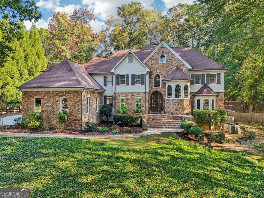 Exquisite French Country estate designed by renowned architect Stephen Fuller-a masterpiece of timeless elegance and luxury living. From the grand two-story entryway with dual staircases to the richly detailed coffered and trey ceilings, hardwood floors, and intricate trim work, every inch of this home exudes sophistication. The updated kitchen is a chef's delight, featuring stainless steel appliances, granite countertops, a gas range, and a wall oven. The spacious kitchen and breakfast room flow seamlessly into a bright sunroom, perfect for relaxed mornings or entertaining. An oversized pantry with a second refrigerator provides exceptional storage and convenience. The primary suite with fireplace and a recently remodeled spa-like bath offers a serene retreat, while upstairs you'll find three additional bedrooms and two full bathrooms, providing ample space for family or guests. The finished terrace level is an entertainer's dream, complete with a pub-style bar, theater room, guest suite, and full bath. Enjoy the warmth and ambiance of four fireplaces throughout the home, each adding charm and comfort to the living spaces. Step outside to the private, professionally landscaped backyard surrounded by evergreens and featuring flagstone walkways, a sparkling pool, and a relaxing spa-your personal oasis. Located in the sought-after Polo Golf and Country Club, within walking distance to Vickery Village, and just minutes from Cumming City Center, Halcyon, Big Creek Greenway, top-rated schools, and premier shopping and dining. With luxurious finishes and exceptional craftsmanship throughout, this residence offers both grandeur and warmth in one perfect package.