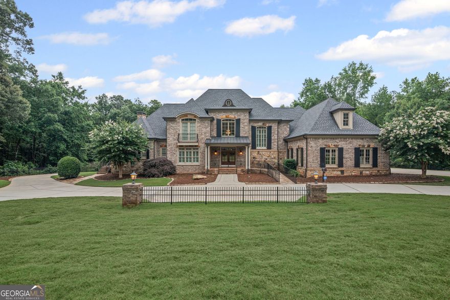 SPECTACULAR GATED CUSTOM HOME ON 12.18 +/- ACRES With Gorgeous Pool And Pool House. Circle Driveway, Three Car Garage, Playhouse. Elegant double foyer entrance, hardwood floors, elevator, columns, wheelchair accessible. Kitchen with granite counters, island, S.S. appliances, ample cabinet space, walk-in pantry, breakfast area w/sun room access. Living room w/ floor to ceiling stone fireplace, built-in bookshelves & cabinets, coffered ceiling, large laundry room w/sink, side entrance, separate dining room, office or nursery, off primary bedroom with sunroom access. Spacious primary bedroom on main with deck and sunroom access, spectacular primary bath w/tiled Floor, walk-in tiled shower, jacuzzi tub, double vanity. Walk in closets with built ins. Three bedrooms and two baths upstairs with hardwood floors, tiled bathrooms, and second level porch access. Finished basement with custom bar, fireplace, full bathroom, movie room, walkout to pool, large utility room, garage door. Mechanical rooms. Gorgeous pool, hot tub and waterfall surrounded by stone patio, outdoor kitchen and fireplace, pool house with bathroom. Mostly wooded beautiful 12.18 +/- acres with riding trails and paths. Easy access to I-85, Newnan, Piedmont Hospital, City of Hope, and Ashley Park. You must see this property to believe it!