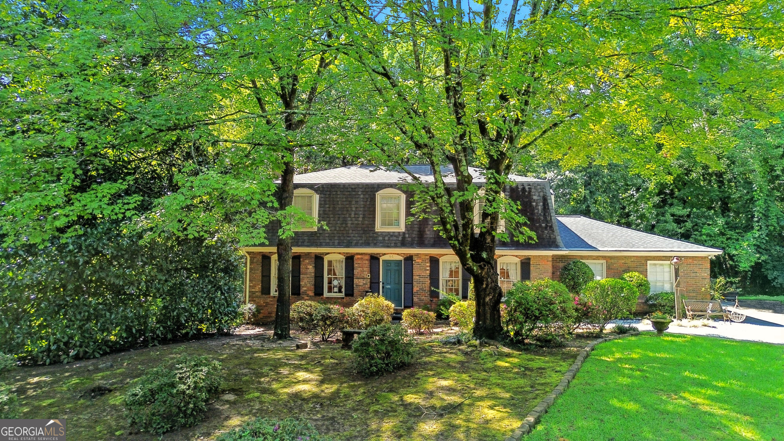 This four-sided brick French Provincial home is nestled in a well-established neighborhood just minutes from downtown Toccoa. A distinctive Mansard roof, inspired by French country estates, enhances the home's elegant facade and creates a warm, welcoming entry. The main level features a foyer entrance, updated kitchen with quartz countertops and a coffee bar, a spacious great room with built-in bookshelves flanking a masonry wood-burning fireplace, a formal dining room, sunroom, study, and a half bath. Beadboard ceilings and recessed lighting add charm and character throughout this level. Upstairs, four oversized bedrooms fill with natural light from abundant windows, accompanied by two full baths. The finished basement offers a second masonry fireplace with gas logs and generous space for entertaining family and friends. Dual HVAC systems serve the main and upper levels for year-round comfort.