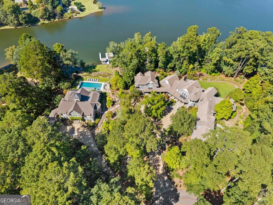 One-of-a-Kind Multigenerational Lakefront Estate. Three stunning homes nestled in almost 3 acres perfectly positioned on the main side of Reynolds, this location places you minutes by boat or car from the Ritz-Carlton, Lake Club, Tavern, Richland Pointe, and world-class golf courses. No other property within Reynolds compares. This is a rare opportunity to own one of the most remarkable lakefront compounds ever offered at Reynolds Lake Oconee.An extraordinary three-property estate with more than 650 feet of water frontage crafted by DreamBuilt and designed by Don Beck, the architect behind the Ritz Carlton Reynolds Lake Oconee. This is your Hamptons home at the lake. Main Residence: 5 bedrooms, 5 full baths, 4 half baths. Featuring a spacious chef's kitchen, main-level primary suite, wraparound porches overlooking the lake, a terrace-level family retreat with bar and second kitchen, and expansive stone patios leading to a manicured backyard with water features, outdoor shower, and lakeside fire pit. Includes a 3-car garage with porte-cochere and a private 2-bedroom apartment above. Guest House: Just steps away, connected by a charming front porch, this 3-bedroom, 3-bath residence offers its own kitchen, living room, and lake-view balcony-ideal for extended family or friends. Pool House: A newly built showpiece designed for entertaining and relaxation. With 5 bedrooms, 5 baths, a spacious great room accented by hand-hewn Heart Stone beams (installed without nails for architectural authenticity), chef's kitchen, butler's bar, bunk room, and loft space. Outdoor resort-style living shines with a luxury pool, expansive stone patio, outdoor kitchen, swing beds, fireplace, and covered balconies with stunning lake views.This estate offers a resort-style outdoor experience with two private boat docks, a beach area, mature landscaping, and winding trails that feel like your own private resort. From morning walks along manicured paths to evenings around the lakeside firepit, every detail celebrates the outdoor lifestyle. This is the only property of its kind in Reynolds main close to all the amenities-similar estates are located more than 30 minutes away.With Two available memberships and a design intended to bring families together across generations, this estate is more than a home-it's a legacy. Offering architectural pedigree, impeccable craftsmanship, and a setting that cannot be replicated, 1070 & 1080 Cotton Gin is truly one of Reynolds' crown jewels.