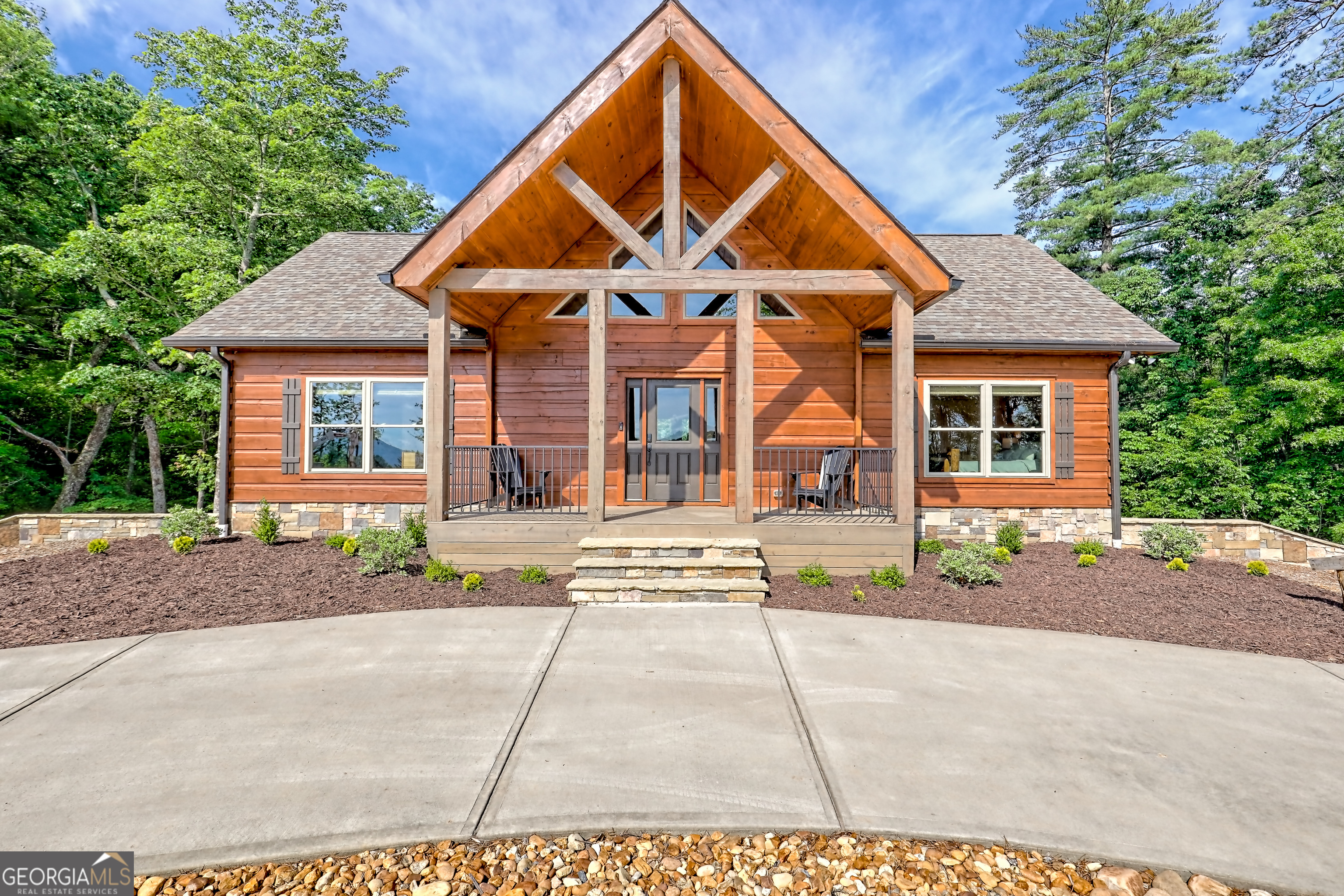 Escape to the serenity of Lake Burton and the North Georgia mountains in this beautifully crafted 4-bedroom, 3-bathroom custom log cabin, nestled in the Summit at Lake Burton, a private gated community just over a mile from the iconic LaPrade's Marina. Thoughtfully designed and newly built, this home exudes rustic elegance with soaring wood-beamed ceilings, freshly-scented pine walls, and expansive windows that bathe the open living spaces with natural light. The main level boasts a spacious primary suite and a comfortable guest bedroom/bathroom-all wrapped in rustic charm and natural light. Upstairs, a versatile loft provides the perfect space for a home office, reading nook, or kids' hangout. The terrace level is designed for fun and functionality, with two additional bedrooms, a full bathroom, a stylish bar area, foosball and air hockey tables, and a cozy media space anchored by a massive TV and plush sectional---ideal for movie nights or game-day gatherings. Step outside to experience the magic of mountain living across two levels of expansive decks. Enjoy a soak in the private hot tub, rinse off in the outdoor shower, or gather around the fire pit strung with twinkling cafe lights---the perfect backdrop for storytelling and stargazing. Additional highlights include a circle driveway for easy access and ample parking, and thoughtful finishes throughout that blend rustic elegance with modern comfort. In additional to the amenities of Lake Burton and the North Georgia mountains, downtown Clayton is just a short drive away, where you can immerse yourself in local culture, browse charming boutiques, and indulge in the many restaurants and attractions the town has to offer. Whether you're looking for a full-time mountain escape or the ultimate weekend getaway, 117 Ivy Ridge Way is a turn-key sanctuary that invites you to relax, unwind, and savor the best of Lake Burton living.