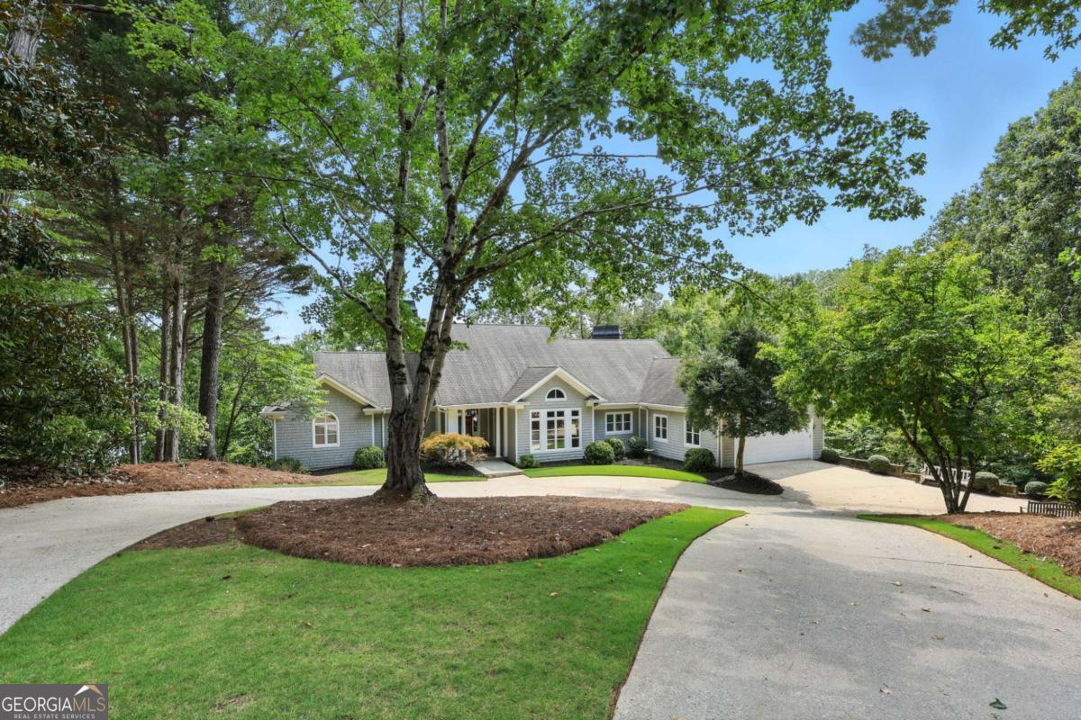 Discover your perfect lakeside retreat at 951 East Lake Drive-a charming lake house designed by well loved, local architect Jack Bailey, every detail was meticulously planned. Perfectly placed right outside the city limits, this layout offers an effortless flow, making it perfect for entertaining family and friends. Nearly every room offers a view of the lake! The primary suite on the main floor boasts a spacious layout with tall ceilings, a fireplace and a cozy screened porch overlooking the private backyard with beautiful views of the lake. You will also find a large formal dining room, a spacious living room with lots of natural light and a warm den with fireplace adjacent to the modern kitchen and an expansive deck, perfect for hosting neighborhood gatherings. The lower level offers three bedrooms, 2 bathrooms, a secondary family room with a fireplace that leads to one of the decks for easy entertaining and convenient lake/dock access. An unfinished space on the lower level provides flexible options ideal for a home office, gym, studio, or an additional bedroom/bath. A true retreat, blending comfort, style, and the serenity of lakefront living! Call Beverly or Margie to schedule a private showing.