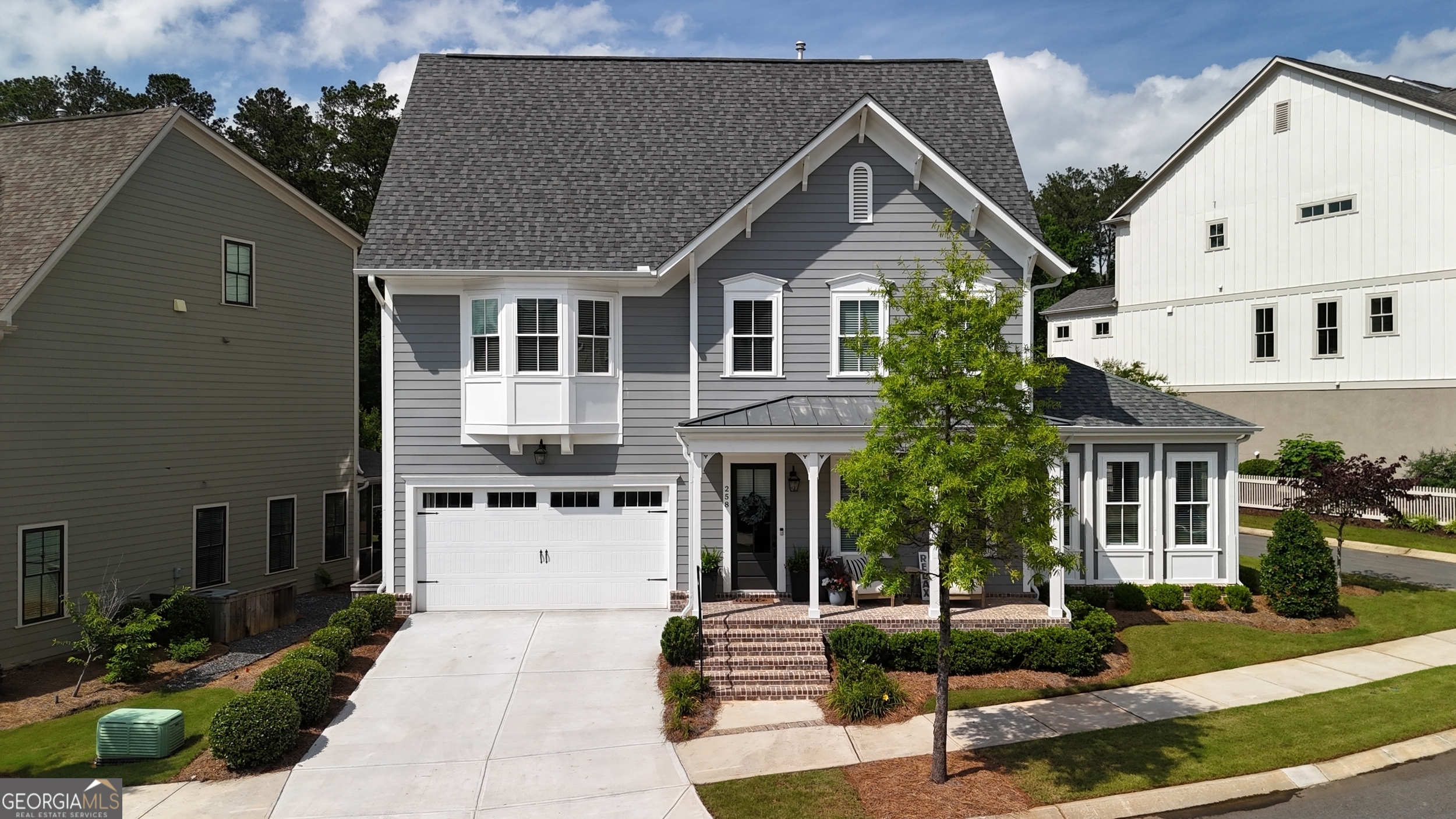 Exquisite Three-Story John Wieland Home in Sought After South on Main near Woodstock Downtown is a must see! Enjoy the convenience of walking to the Best Restaurants, City Parks, Greenprint Trails, Boutiques, Shopping, Farmers Market, Elm Street Arts, New Amphitheater and MUCH MORE!!! This community has it all to include a beautiful clubhouse with workout facility, community amphitheater, playground, two dog parks and a community garden. Step onto the gorgeous rocking chair front porch leading to an open and modern floor plan featuring beautiful hardwood floors throughout, a large family room with a gas fireplace, a bright and airy sunroom providing additional square footage and seating, a chef's kitchen equipped with quartz countertops, a farmhouse sink, built-in oven/microwave, a large island with pendant lighting, a large dining area, and a sizable pantry. The second floor boasts a large decorative bookshelf, an oversized primary bedroom offering a luxurious retreat with a spa-like en-suite bathroom featuring a large free standing tub and a tile shower with seat, two spacious secondary bedrooms with walk-in closets, and a convenient laundry room with tile floors, built-in cabinets and sink. The third floor is designed for entertainment with a media room, an additional bedroom, and a full bath. The stunning private backyard unlocks a covered porch, fenced backyard, upgraded stone pavers, large ceiling fan and eye catching landscape. If you are desiring to be in the heart of Woodstock, look no further, welcome home!