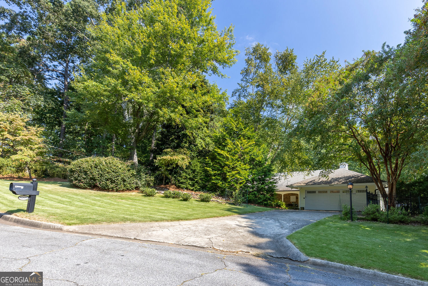 Discover an extraordinary one-and-a-half story custom residence, perfectly tucked away on a picturesque, professionally landscaped estate-sized cul-de-sac lot of over an acre. A private sanctuary, this property offers terraced walkways, lush gardens, and a serene backyard retreat with a heated Pebble Tec pool, waterfall spa, custom stonework, and seasonal views of Lake Northridge. Every detail inside and out reflects timeless craftsmanship and thoughtful design. The home welcomes with a charming front porch and tranquil fish pond, opening into a dramatic two-story stone foyer. Vaulted, beamed tongue-and-groove ceilings, expansive casement windows, and gleaming hardwood floors create a warm and airy flow throughout. The open-concept living and dining rooms boast soaring 20' ceilings, while the beautifully renovated kitchen is a chef's dream-custom cabinetry with Rev-a-Chef accessories, quartzite countertops, tile backsplash, center island with seating, stainless steel appliances including gas cooktop and vent hood, microwave drawer, and a convenient Butler's Pantry. A separate breakfast room offers the perfect everyday gathering spot, while the spacious family room-with its Palladian window, stacked-stone fireplace, and wet bar-opens directly to the terrace, blending indoor and outdoor living for effortless entertaining. The terrace itself overlooks the sparkling heated pool and fenced backyard, designed for both relaxation and family enjoyment. Features include lighted walkways and stairs, a pool cabana conveniently located off the terrace, pool storage, custom stone terraces, Trex decking, an automatic pool cover, and Jandy Aqua Link RS system-all creating a resort-like setting for gatherings large or small. The main-level primary suite offers a peaceful retreat with his-and-hers closets and a spa-like bath. Two additional bedrooms (one with custom built-ins) share a hall bath, while a large laundry room enhances main-level convenience. Upstairs, a light-filled loft with skylights overlooks the living room, alongside a spacious bedroom with full bath and generous walk-in attic storage. The terrace level features soaring ceilings and a fully equipped in-law suite/apartment with private entrance, including living and dining rooms, a full kitchen, bedroom, and full bath with step-less shower, plus abundant storage and workshop space. This exceptional property is ideally located near top-rated public and private schools, shopping, and dining, with easy access to Sandy Springs City Center, Dunwoody Village, downtown Roswell and Alpharetta, and GA 400. Residents enjoy a private neighborhood entrance to the scenic Island Ford Chattahoochee River Park, as well as proximity to Dunwoody Golf & Country Club. A rare offering, this home combines the beauty of nature, architectural distinction, and versatile family living into one unforgettable estate.