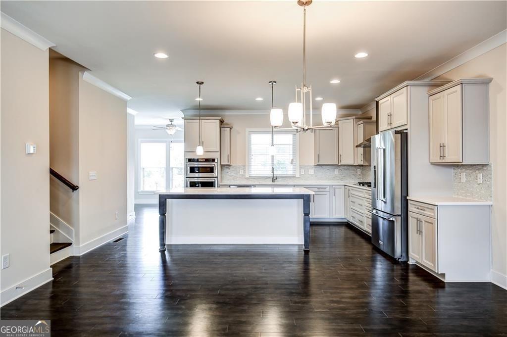 Discover upscale living in this beautifully designed modern townhome located in the heart of Buckhead. Just minutes from Lenox Square, Phipps Plaza, and Buckhead's world-class shopping, dining, and entertainment, this home offers unbeatable convenience with easy access to I-85, GA-400, MARTA, and Midtown's vibrant arts and nightlife. Inside, you'll find a spacious, open floor plan filled with natural light and upscale finishes. The gourmet kitchen is a chef's dream, featuring sleek quartz countertops, a designer tiled backsplash, and premium KitchenAid stainless steel appliances, including a built-in oven, cooktop, and an oversized island perfect for entertaining. A large pantry provides ample storage. Adjacent to the kitchen, a bright sunroom offers a versatile space ideal for a home office, keeping area, or additional sitting area. Upstairs, the primary suite is a private retreat with hardwood floors, two generous closets, and a spa-inspired bathroom with a frameless glass shower. Private deck directly from the bedroom provides a place for morning coffee or evening relaxation. This townhome also boasts multiple outdoor living areas, making it a rare find in such a prime location.