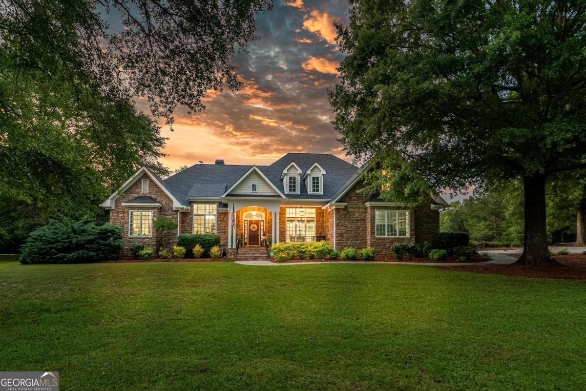 Welcome to your dream property, a meticulously maintained and beautifully designed home set on 15 scenic acres, offering the perfect blend of luxury, comfort, and natural beauty. As you step inside, you're welcomed by a striking living area featuring custom built-ins and a beautiful stone fireplace. This inviting space flows seamlessly into a well-appointed kitchen with custom cabinetry, offering both style and function. The adjoining dining area is perfect for gathering with family and friends. The primary suite is spacious, charming, and filled with natural warmth. The recently renovated primary bath exudes luxury and thoughtful design, while the generously sized closet adds convenience and ease to everyday living. At the front of the home, there's a dedicated office space, perfect for remote work or quiet study and a formal dining area which creates the perfect setting for special gatherings. The main floor, which is anchored by beautiful hardwood flooring, also includes two additional bedrooms and two and half secondary bathrooms. The laundry room is just off the kitchen and connects directly to the attached two-car garage. Upstairs, the fourth bedroom offers flexibility as a hobby area, or anything you need, complete with its own half bath for added convenience. The home's exterior is truly exceptional, offering a resort-like experience right in your own backyard. The screened-in porch is a serene retreat, with ample room for seating to relax and take in the beautifully landscaped views. Step outside to the stunning PebbleTec saltwater pool, perfectly sized for cooling off on hot summer days. Nearby, a charming gazebo invites you to enjoy poolside dining. On those cool nights, gather around the firepit and enjoy the warmth and ambiance under the stars. As you follow the stone pathway, you'll find a versatile recreation room adorned with shiplap walls and custom shelving, ideal for gatherings or quiet retreats. It also includes a convenient half bath with potential for expansion. Slide open the barn door to reveal a dream workshop space, perfect for projects and creativity. Still want more? Head over to "The Firehouse," another inviting spot designed for hobbies or hangouts. The backyard is fully enclosed with durable aluminum fencing, providing a safe and secure space for your pets to roam freely. Beyond the manicured lawn, you'll uncover 11 wooded acres with well-maintained trails, bordered by a flowing creek. It's a peaceful and private retreat, offering a true escape into the beauty of nature. Every detail of this property has been thoughtfully designed and beautifully finished. Offering peaceful country living, this property is located 15 minutes from the amenities of both Greensboro and Madison, and only 20 minutes from Lake Oconee access. Schedule your showing today and experience its charm firsthand.