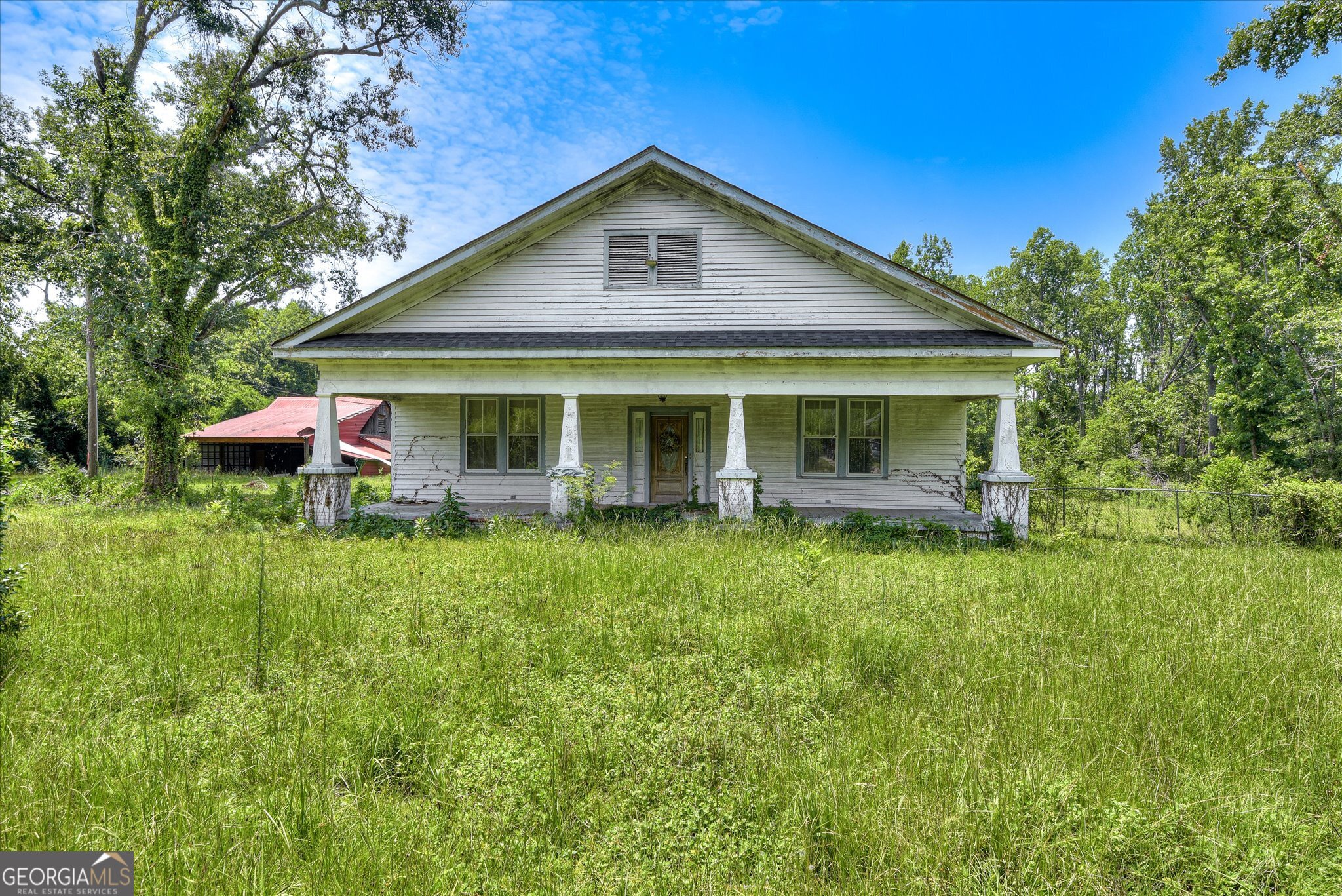 Investor's dream meets historic charm with this rare 8.5-acre dual-parcel opportunity at 2910 & 2920 Milledgeville Rd, just minutes from downtown Augusta. The front parcel, 2910 Milledgeville Rd, features a 2,623 sq ft historic ranch home on 2.4 acres, complete with a rocking chair front porch, mature shade trees, a 450 sq ft covered rear patio, vintage kitchen, wood-ceiling living room with a statement fireplace, enclosed sunroom, and updated full bath with dual sinks. While the home needs TLC, it offers great bones and character for restoration. The second parcel, 2920 Milledgeville Rd, offers 6.08 acres of cleared, flat land - ideal for future development, recreational use, or long-term investment - with flexible zoning and a detached red metal-roof barn/workshop already equipped with utilities. Surrounded by natural privacy and located in an area experiencing growth and revitalization, with major county park and trail projects underway, this property is sold as-is and ideal for investors, builders, or buyers seeking land, space, and potential in a prime Augusta location.