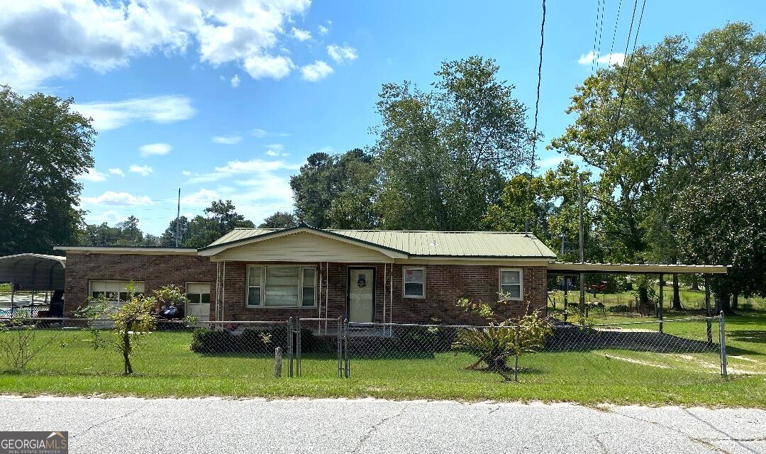 Charming home in town with inground pool area great for entertaining. There is a bathroom/changing room in the pool area. Two bedrooms, one full bathroom. Large family room/main room off the carport that is open to kitchen area. Kitchen is centrally located with gas stove. This home has large two car garage/shop and has large motor home size covered parking for RV and a handihouse/shed for extra storage. This is a nice private home being sold as-is, in need of some TLC, but is in a great location with a great entertainment area with inground pool. City water/sewer.