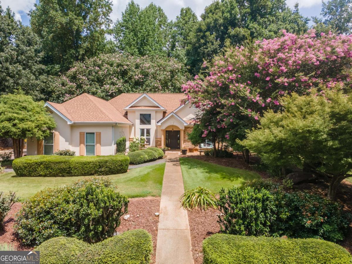 Welcome to this beautiful, stepless Ranch home featuring a split bedroom floor plan and located in one of the best-established neighborhoods Flowery Branch has to offer! Partially open concept, wood burning, stacked stone fireplace with gas starter, separate dining room, large owner's suite with custom closet and a spa-like bathroom that boasts a separate floor to ceiling walk-in, tiled shower and huge soaking tub. In addition, enjoy those cool evenings this fall relaxing in your hot tub, privately located off the screened-in "game day" porch. A gorgeously landscaped yard with lots of privacy in both the front and back create the perfect spot for morning coffee or evening chats with friends and family. Walk the almost three miles of paved walking trails that meander through the woods and alongside the neighborhood's three lakes, tennis/pickleball court, basketball area, playground and swimming pool/club house. Great school district and centrally located to shops, grocery stores, restaurants, library, parks, Lake Lanier (just minutes away) and many different places of worship to choose from. Come take a look for yourself and put your happy house hunting days to an end!