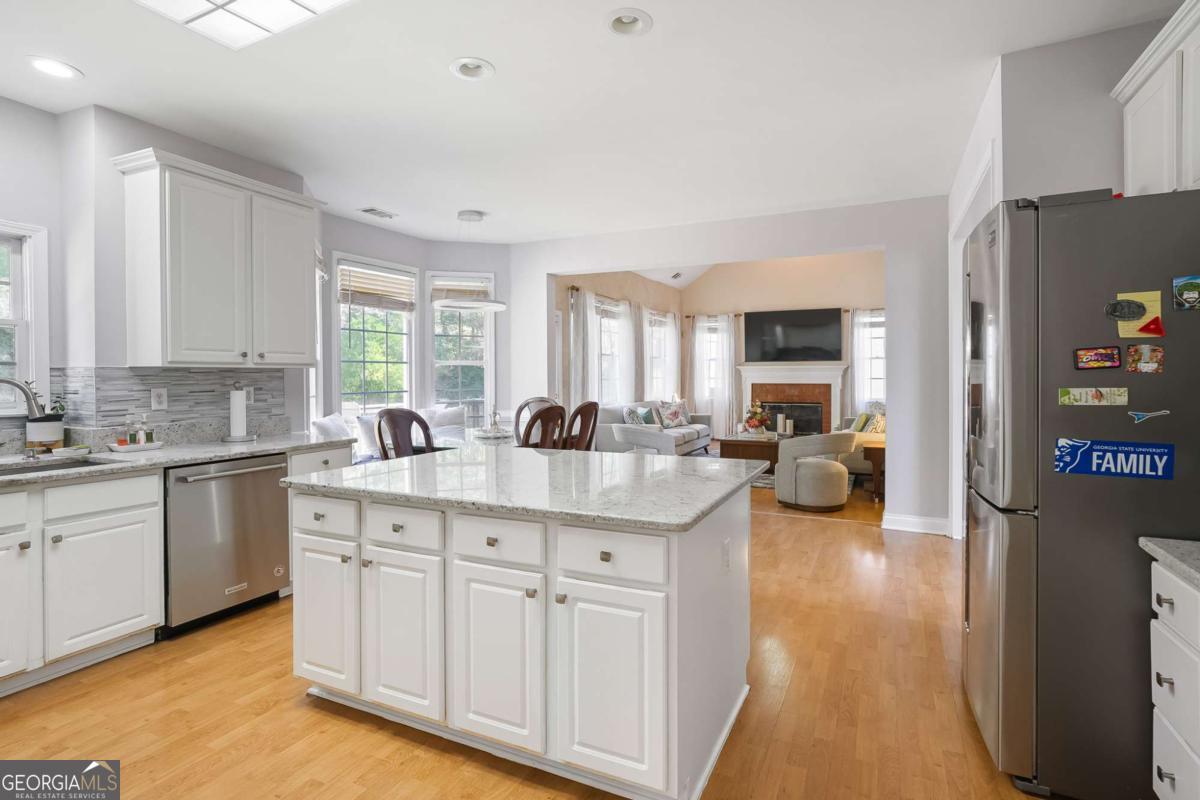 Welcome to this stunning brick-front home featuring 5 bedrooms, 3.5 bathrooms, and a full finished walkout basement. The terrace level offers a versatile guest or in-law suite with a full bath, plus a bonus room ideal for a home gym, media room, or game area. The main level boasts a gourmet kitchen with a breakfast area, an elegant 12+ seating dining room, a formal living room, and a spacious family room with a cozy fireplace that opens to the deck-perfect for entertaining or relaxing while enjoying the private backyard. A convenient half bath is also located on the main floor for guests. Step inside through the dramatic two-story foyer with beautiful wooden stairs leading to the upper level. Upstairs, you'll find a luxurious owner's suite and three additional generously sized bedrooms. The laundry room is centrally located for convenience, and a secondary staircase provides easy access to the family room. Located in a welcoming community with sidewalks, underground utilities, and a small HOA, this home is just minutes from parks, restaurants, and shopping. Best of all, it's in the highly sought-after Brookwood High School district. Don't miss your chance to own this incredible property-it won't last long!