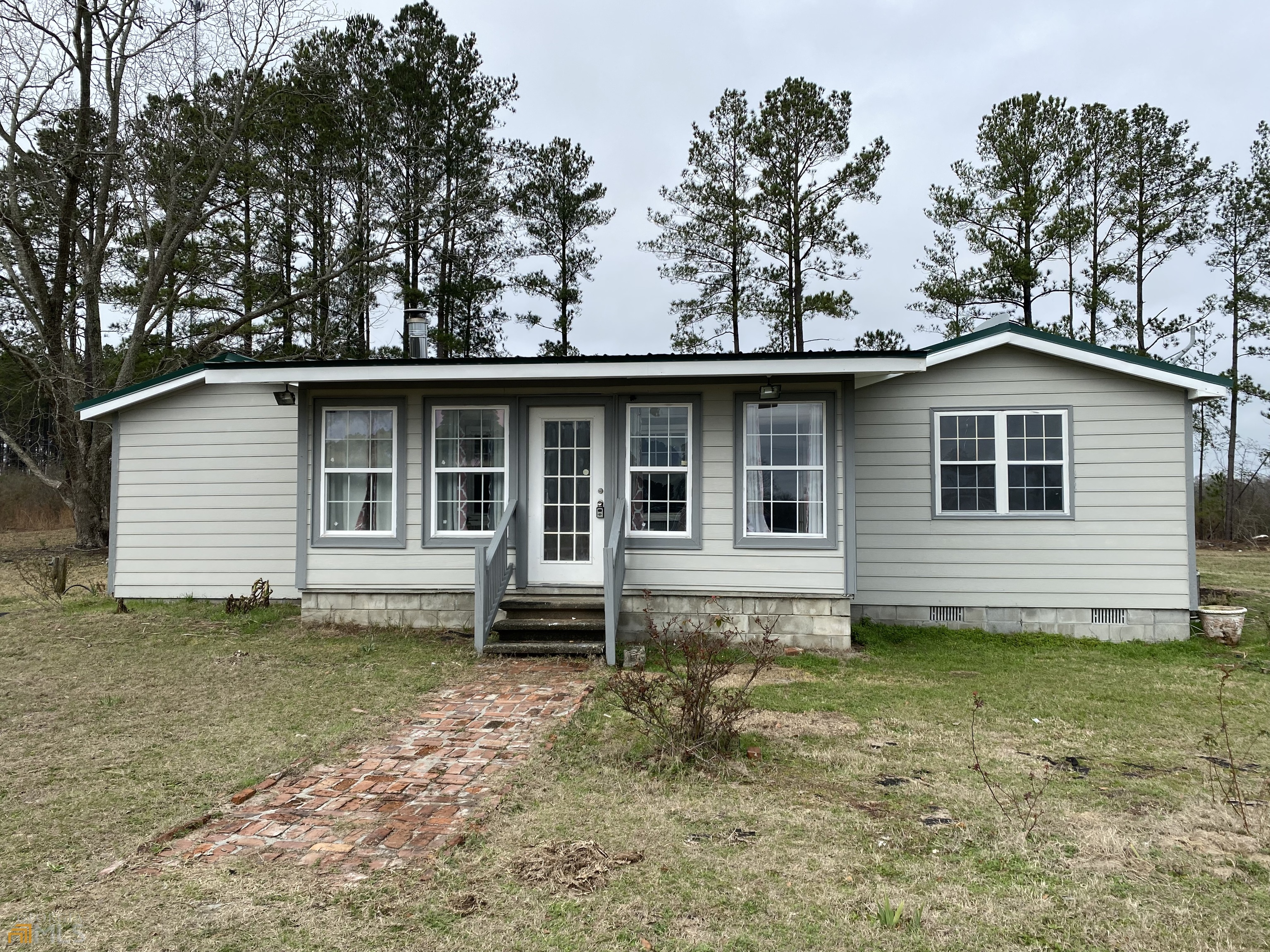 If quiet, country living is what you're looking for, this is the home for you! Sitting on a cleared and level 1 acre lot, there's plenty of room for gardening, adding on or a pool. Enjoy the sunrise coming over the fields in the fully enclosed sunroom in the front of the house. Also enjoy the cool breeze from the large screened in deck with storage area on the back side of the house. Large master bedroom with walk-in closet and the master bath has a double vanity. Split floor plan with the other bedroom and full bath, plus a bonus room, could be office or another bedroom (it just doesn't have a closet) on the other side of house. The kitchen has a ton of cabinet space with an island in the middle. It also has a nice sized utility room with washer and dryer hookups. The roof is metal and only 2 years old, new floors and fresh paint done in the last 6 months. Also, it's only 8.6 miles from the University Aviation School. Don't let this gem pass you by!