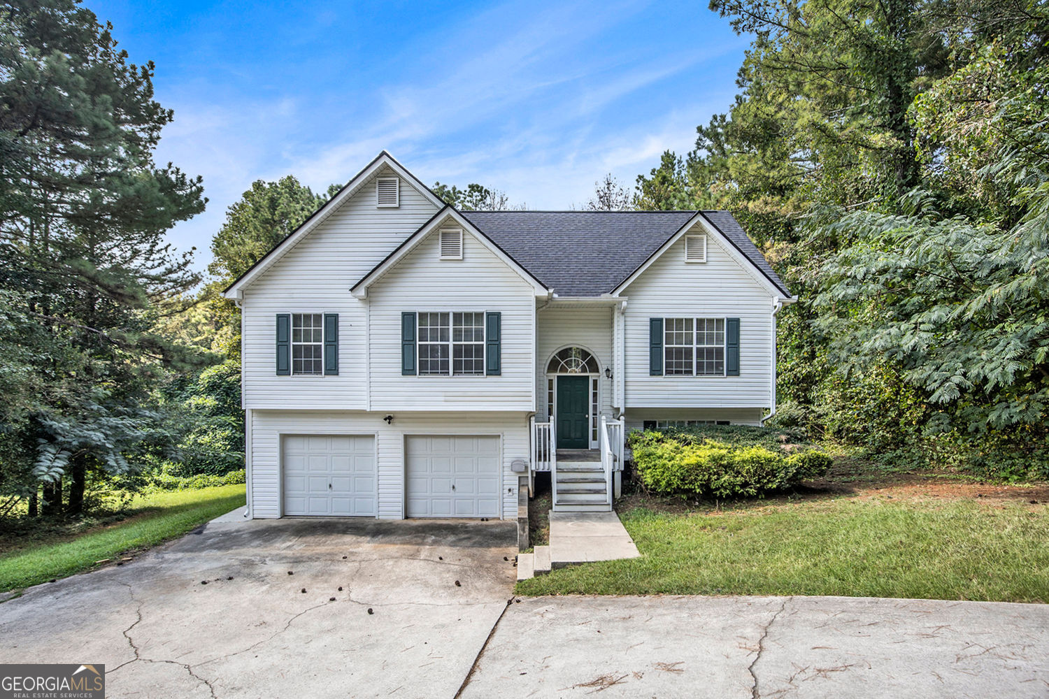 Welcome to this beautifully maintained two-story split-level home, offering the perfect blend of comfort, space, and functionality. Nestled on a little over a half acre lot, this property boasts a private backyard lined with serene wooded areas, providing a peaceful retreat just steps from your door. Step inside to an open-concept main living area featuring soaring vaulted ceilings that fill the space with natural light. The dining area opens directly onto a large back deck, ideal for entertaining or relaxing while enjoying the tranquil views. The master suite is a true retreat with tray ceilings, a spacious walk-in closet, and a luxurious en suite bathroom complete with a soaking tub and separate shower and tons of natural light. Two additional bedrooms are conveniently located on the same level, making this home perfect for families or guests. Laminate flooring runs throughout, offering durability and a modern touch. The lower level features a partially finished basement, perfect for a home office, gym, or media room, along with a laundry area and ample storage space. A two-car garage provides even more storage and includes outside access to the backyard. Don't miss the opportunity to own this inviting home that combines space, style, and privacy-all in one beautiful package!