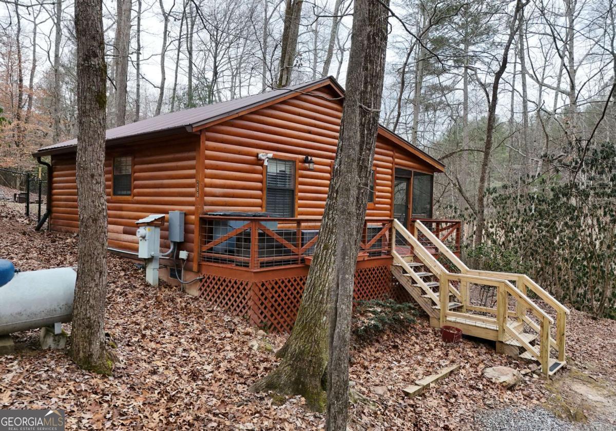 This absolutely adorable and very well-maintained 1BR - 1BA Cabin sits on 0.55 acres with 250+ feet of loud water on the picturesque Collins Creek, which is a Hemptown Creek Tributary. There are no restrictions on this property. Very successful short term rental generating $42K in 2024. Being sold fully furnished / turnkey, there is plenty of parking for guests and although this is a small cabin, the space is very well laid out. Refurbished kitchen with new appliances, granite countertops, and cabinets and also refurbished the bathroom with new sink, shower, hardware, etc. Located approximately 15 minutes from both Blue Ridge and Blairsville, you will have your pick of shopping, restaurants, and all that the beautiful North Georgia Mountains have to offer, including hiking, rafting, fishing, USFS land etc. Don't delay - in this market, this cabin will not last long!