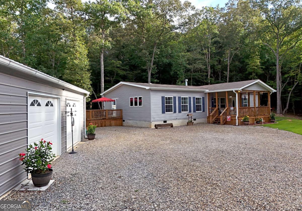 Discover this beautifully upgraded Timberland Elite manufactured home by Cavco, built in February 2022 and set on a permanent foundation. This pristine, energy-efficient residence offers 1,984 square feet of meticulously designed living space. As you explore the property, you'll appreciate the thoughtful layout, which features two porches-one open and wheelchair accessible-while each is covered for shelter, both measuring 12x20, providing ample room for relaxation. The expansive 30x50 garage/workshop boasts oversized insulated overhead doors (8 feet tall and 10 feet wide), four windows, and two walkout doors. It is stubbed for a bathroom, making it perfect for a variety of uses. This property is truly a gem, set on 3 acres of stunning landscape. There's much to take in on the inside, so step in and find soaring 9-foot ceilings that enhance the sense of space in this beautifully maintained home. With high-efficiency insulation, 2x8 floor joists, double-pane energy-efficient windows, and a 4-ton energy-efficient heat pump, every detail has been carefully considered to ensure comfort and sustainability. Every woman will appreciate the clean, well-kept environment that warmly invites everyone, including those using wheelchairs. The wood cabinets throughout the home feature a consistent color and design, ensuring a beautiful aesthetic from room to room. The large kitchen is a true delight for anyone who loves to cook. Its spacious layout not only enhances functionality but also creates an inviting atmosphere for family gatherings. You'll smile as you walk through this expansive kitchen, which includes a dedicated area for updating your cookbooks or storing cherished recipes. This property is truly a gem, set on 3 acres of stunning landscape. A detailed list of improvements is available, showcasing the extensive upgrades that make this home stand out. Don't miss the opportunity to experience this exceptional property-come see for yourself and envision your future here!