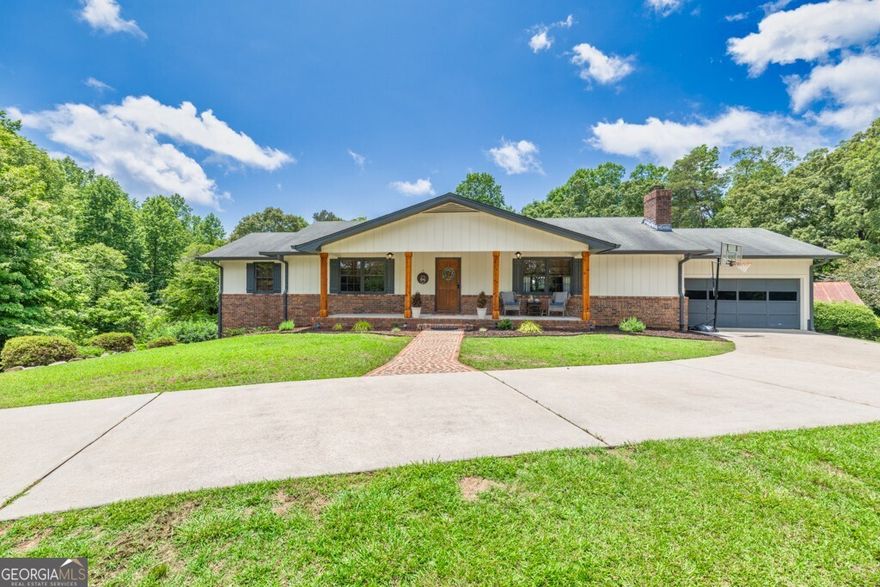 renovated ranch on 4.85 acres in North Ga. Conveniently located in North Hall this house greets you with an expansive covered rocking chair front porch and a privately situated lot. Upon entry through the entrance foyer you will find a generously sized living room with accented wooden beams, built in cabinets surrounding the fireplace, and new flooring. The formal dining room easily holds a 6 person table with extra space. The kitchen has recently been updated with butcher block counters, a modern tile backsplash and also has a coffee bar in addition to stainless steel appliances. All bathrooms have been wonderfully updated with new vanities, shiplap accents, & modern mirrors & fixtures. The partial unfinished basement is great for storage and has been previously used as a bedroom as well. Out back is a quaint stone patio and a carriage house that could easily be transformed back into a guest house, in law suite, pool house or could possibly be converted into an airbnb. There are additional structures outside that can be used for storage and the property does have a well in addition to public water. The acreage provides the perfect opportunity for gardens, privacy, multi-generational living and it could also be divided upon approval from the county for further development due to how the land is situated. There is ample parking in addition to the attached garage including a gravel parking pad in front of the house and a separate gravel driveway on the lower end of the property. All of this is located within minutes of Publix, Kroger, dining and schools. Don't miss this wonderful opportunity!