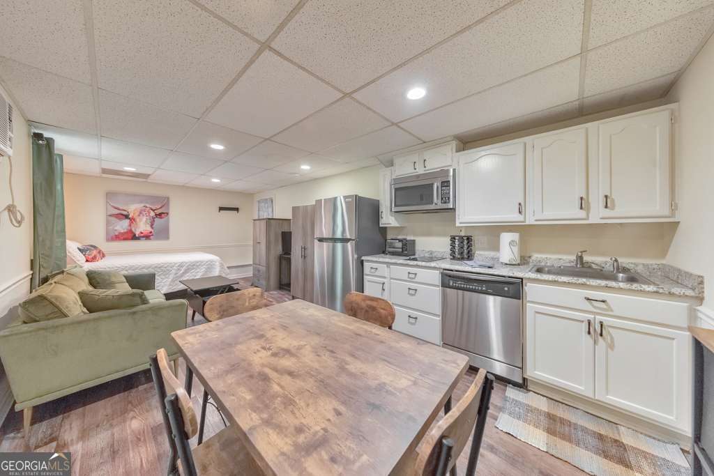 Welcome to this fully furnished studio apartment nestled in the heart of sought-after East Cobb! This basement unit offers everything you need for comfortable, low-maintenance living. The updated kitchenette features white cabinetry, an electric cooktop, microwave, dishwasher, and refrigerator. Enjoy the privacy of your own full bathroom and access to a washer and dryer located in the garage. Step outside to a beautifully landscaped backyard, where a covered patio provides the perfect spot to unwind. Utilities included in rent. One month's rent security deposit, $500 non-refundable pet fee.