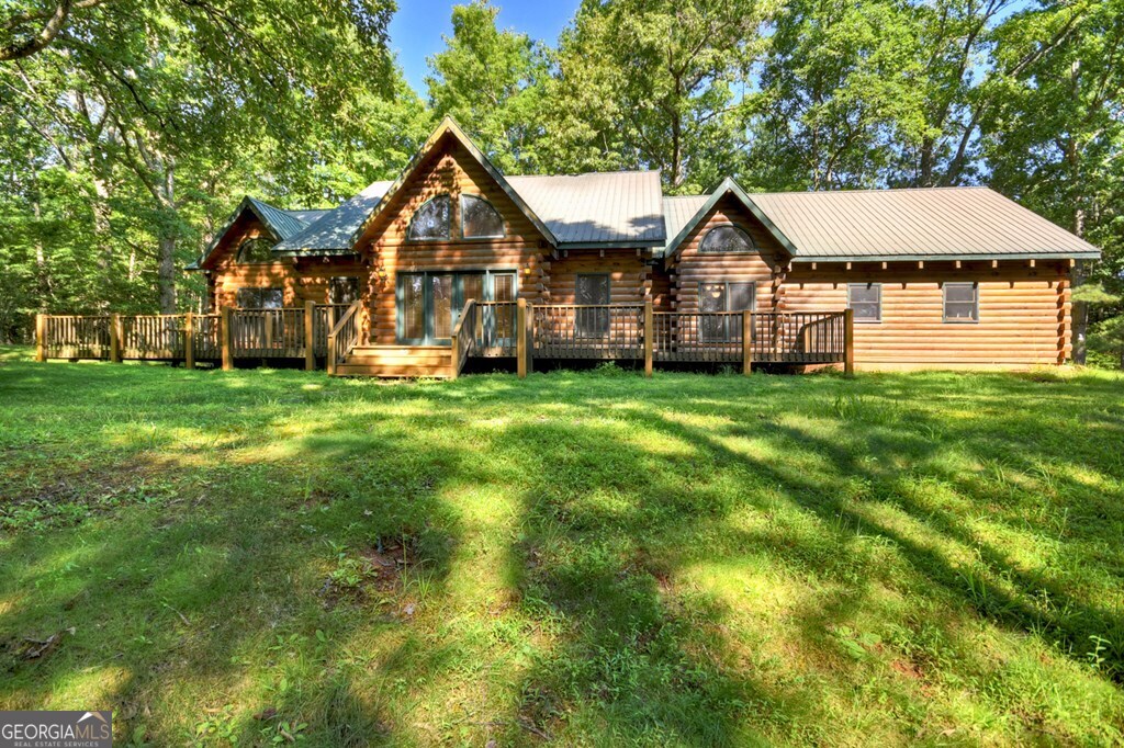 ^MOUNTAIN LIVING - CUSTOM LOG HOME WITH ACREAGE^ Featuring 6.34 beautiful wooded acres which includes the potential of 3 total lots (house + 2 additional buildable lots) in the popular gated community, Wolf Creek Estates located convenient to both downtown McCaysville & Blue Ridge. This property is part of an estate & is being sold "as is". Home does need some repairs & upgrades but the potential is endless with this custom log home! Almost 2,400 sq. ft. of living space featuring 3BR's, 2.5BA's w/ a 2 car attached garage + bonus/flex room above garage (would make great home office, home gym, storage, etc). Open concept floor plan makes for easy living w/ master suite on the main level & 2 additional BR's & BA upstairs. Cathedral ceilings throughout w/ exposed beams, lots of windows allowing for natural light, large, fixed glass windows in living rm, metal roof, hardwood floors throughout & more. Massive floor to ceiling rock fireplace is the focal point of great room. Large screened in porch spans the entire back of home w/ large front porch & wrap around decks. Offering the perfect blend of drywall & wood interior makes this a perfect full-time home or home away from home. Nice level yard w/ picture postcard setting from every angle w/ end of the road privacy! Enjoy convenience to shopping, dining, nearby medial & more yet ultimate privacy tucked away like you're nestled up in the mountains