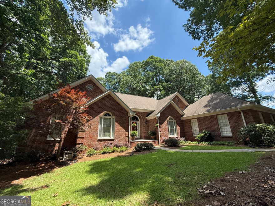 From the moment you enter THE WOODLANDS, there's a sense of quiet elegance and evident care in home ownership. After a short drive past the serene lake, you'll find this home nestled off Emerald Lake Drive. WELCOME to this 4-SIDED BRICK beauty full of comfort, space and privacy. Inside, the main level boasts well-defined living areas that flow seamlessly between the LR and DR to the open-concept Kitchen, Breakfast Area and Family room. Just off the foyer, a PRIVATE HALLWAY leads to the owner's suite, where windows frame peaceful views of the backyard's NATURAL SETTING just beyond the elevated courtyard-style deck. The spacious primary suite includes 2 walk-in closets, 2 vanities, a jacuzzi tub, and a separate shower. NICE. Down the hall are three additional bedrooms and a full-bath with dedicated laundry closet. One of the STANDOUT FEATURES of this home is the floor-to-ceiling windows in the Family Room, overlooking the natural light filling the generously sized screened-in porch. This outside area is elevated overlooking the backyard treetops - a perfect retreat for entertaining, enjoying your morning coffee, or taking a cozy Sunday nap. BACK INSIDE the finished basement offers even more space: a MEDIA OR GAMING AREA and another section that's big enough for the present gym equipment, weights, foosball and ping pong table. There's also a workbench in the unfinished portion. INTERESTED in MORE ROOM? This home has two more spaces just waiting to be finished - one on the 2nd story level and the other in the basement - each with a full bath already plumbed. That's potential for 6 bedrooms and 4.5 baths! All this, just minutes from Fayetteville shopping and dining & located in the top-ranked Fayette County Whitewater School district. Priced right and ready for you to make it your own. Schedule a showing today!