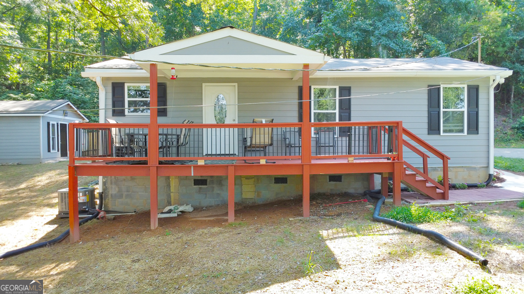 Charming and fully remodeled, this 3 bedroom / 2 bathroom ranch is perfectly tucked away on a private half-acre lot at the end of a quiet street in Silver Creek. While the original foundation was poured in 1950, this home was taken down to the studs in 2024 and was thoughtfully rebuilt with high-end finishes and modern comforts throughout. A welcoming covered front porch invites you inside, where you'll find a cozy family room that flows seamlessly into the galley-style kitchen featuring stone counters and a sunny breakfast area. A separate dining room provides additional space for gatherings. Three generously sized bedrooms share two beautifully updated bathrooms, offering both comfort and functionality. Outside, enjoy the peace and quiet of the serene setting, complete with two storage buildings for all your needs. Conveniently located with easy access to Rome, major roadways, and a wide variety of shopping and dining options, this home combines modern updates with a tranquil lifestyle. The neighboring 3.88-acre parcel is also available, providing endless possibilities for expansion, investment, or creating your own private retreat (FMLS #7635488)
