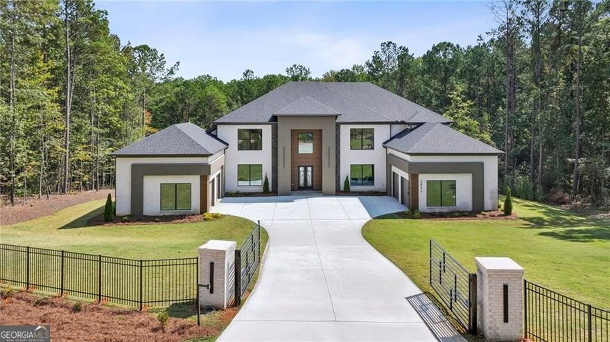 Exceptional new construction in Buford City Schools (#1 in Georgia)!  CONSTRUCTION IS NOW COMPLETE AND HOME IS READY FOR ITS NEW OWNER!  Unique opportunity to own a custom built showcase in small 5 home enclave NOT on a busy street.  Modern detailing and stunning design highlight the beautiful craftsmanship and light-n-bright open floor plan.  The curb appeal is fantastic with the private gate entrance, plus the on-trend colors and wood trim. Walk through the front door and find the light-filled spaces perfect for entertaining and comfortable family living.  The spacious kitchen is gorgeous plus the scullery (or spice kitchen) is a dream come true for the chef in your family.  The spa-like master bathroom is exquisite and the master closet is extra spacious! Upstairs are 4 bedrooms with ensuite bathrooms and large walk-in closets as well as a second laundry room. The terrace is huge and full, and waiting for your personal finishes. Enjoy the covered and uncovered decks on the back of the house. The fabulous, sprawling, and private 2.2-acre lot is the perfect place to build your outdoor dream whether it be a large garden, a swimming pool oasis, or a private tennis court, there is more than enough space to bring your outdoor vision to life!  This is a unique opportunity to own gorgeous new construction on a large, private lot in this tranquil area surrounded by mature trees and lush greenery tucked away from the hustle and bustle of life.  The icing on the cake is the over-sized 4-car garage.  The private access road that services the 5 lots was recently paved.  PLESE CHECK OUT OUR NEW VIDEO!