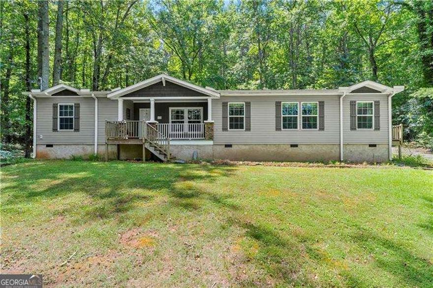 Welcome home to this meticulously well-maintained 3 bedroom, 2 bathroom manufactured home sitting on a permanent foundation! Situated on one level acre of land in the highly desired Sequoyah District, this home has NO HOA and plenty of wooded privacy! Bring your RV or outdoor toys! Over 1900+ SQ FT, inside, you will find an open concept, main living area featuring wooden beams and a stacked stone fireplace. Just off the family room is your spacious kitchen/dining area featuring a large island and stained kitchen cabinets. Your primary suite is over-sized and offers his/hers separate walk-in closets and vanities! Enjoy soaking in your garden tub while enjoying the nature views! On the other side of the home, you will find two secondary bedrooms with large walk-in closets as well as a secondary bathroom. Quick and easy access to East Cherokee Dr; Hwy 5; Hwy 575 - just minutes to all the shopping and dining of Canton, Woodstock or Hickory Flat! FHA and VA approved (Title has been retired)! Come tour this home today!