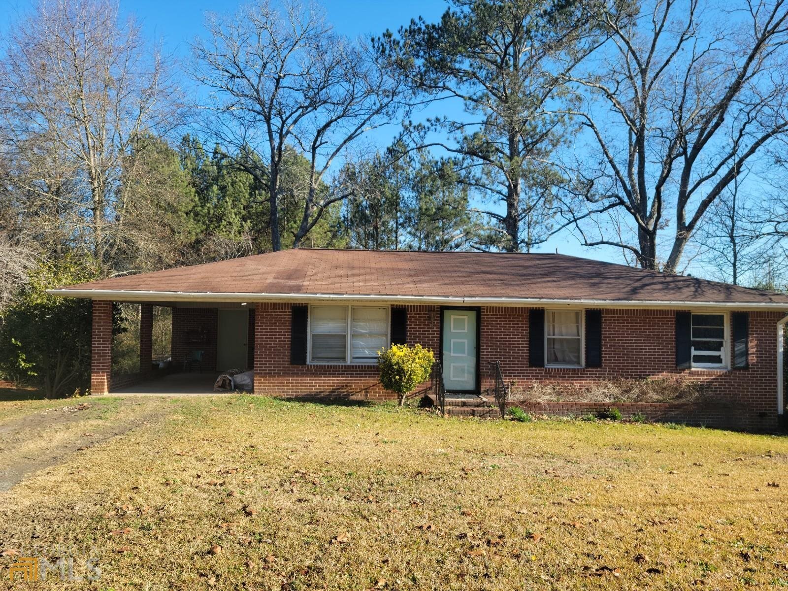 Brick Ranch nestled on 2.08 Acres*Kitchen/Dining area combo*Kitchen features lots of wood cabinets*Laundry Closet in Kitchen*Bonus Room of Kitchen*Living & Bedrooms featuring hardwood floors & ceiling fans*tiled bathrooms*Carport features utility room for storage*two outbuildings*Back yard is camouflaged by tall pines*Sold as is