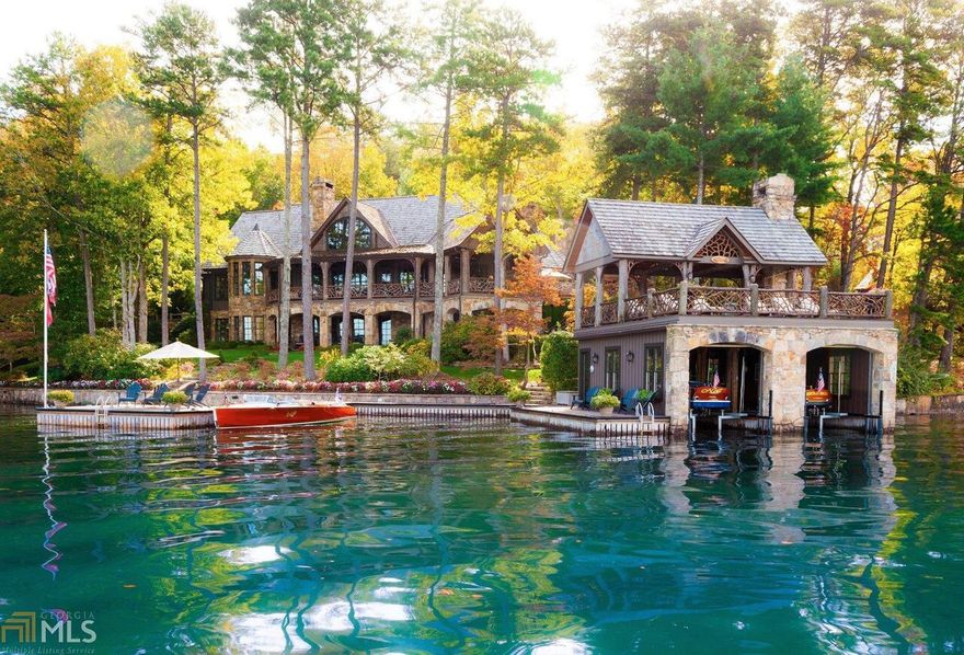 Stone columns & manicured landscaping introduce this enchanting Lake Burton estate. With cedar tree trunk posts & a picturesque stone fireplace, the great room provides a comfortable open space for gathering. A professionally equipped kitchen is the ultimate centerpiece for entertaining w/ 3 islands, 4 dining areas & a cozy fireplace. Great room accesses a grilling deck, covered porch w/stone fireplace & covered rocking chair porch. 2-story boathouse features locust tree trunk posts & beams, mountain laurel railings, stone fireplace and long range mtn & sunset views. Details include master on main, terrace level family room w/ full kitchen & wine cellar, 6 fireplaces, 3-car garage plus 1 car detached w/ workshop, mature fruit orchard & level lakeside lawn.