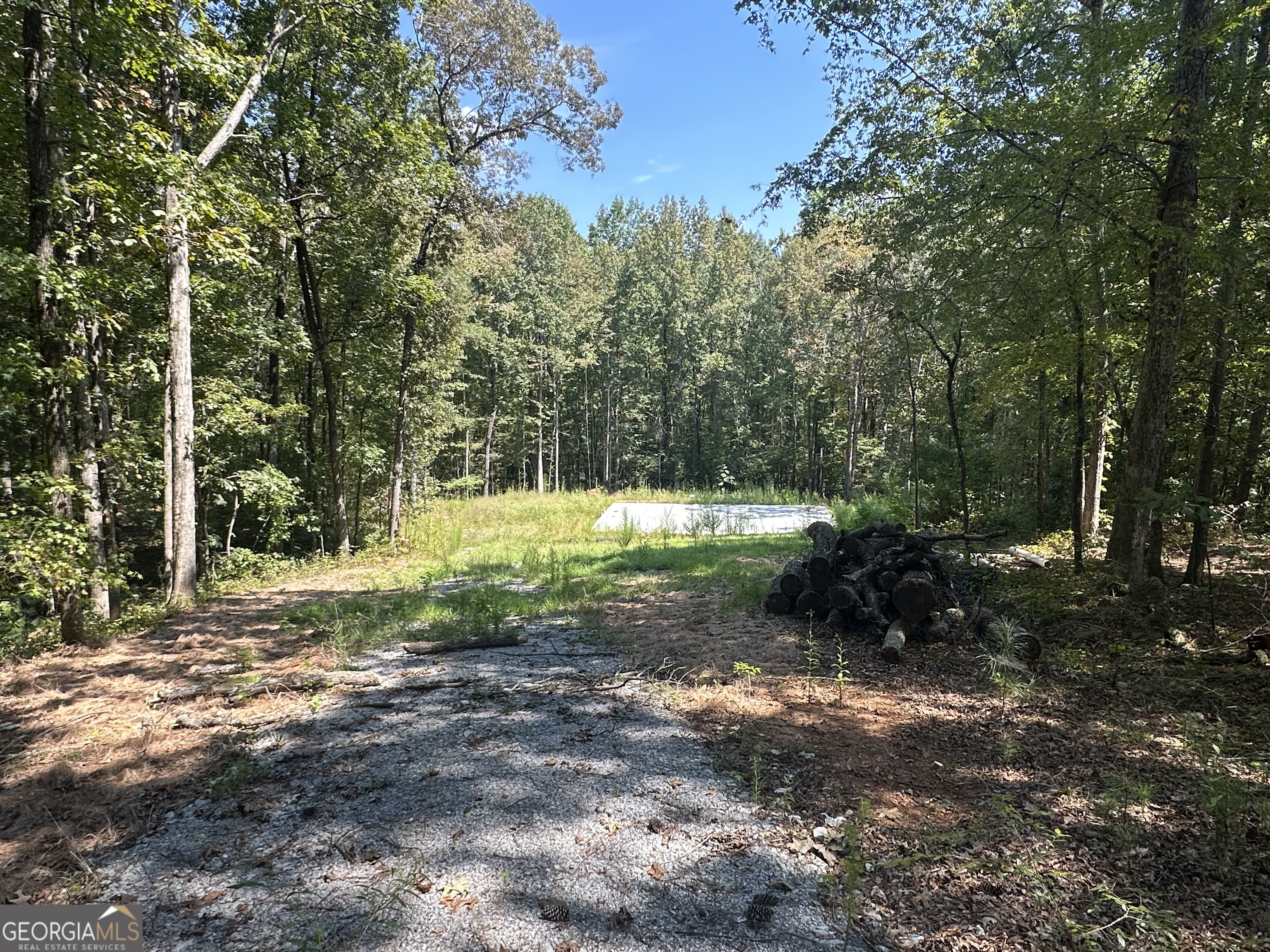 Investor opportunity! Beautiful 1.95 acre lot on a creek with a concrete slab already poured for a barndominium. The seller had a slab poured and a metal building delivered but never got finished with the project. The plans are for a 3br/2ba home at 2100 sq ft. This slab and metal building kit is on site (seller has windows, insulation, and light fixtures in storage). Metal building plans and the floor plans are attached. Septic is not installed yet but seller had a soil test done and it's on file with the county. Water meter is installed at the street. Creek Ridge is a small established subdivision in a quiet area of Winterville.