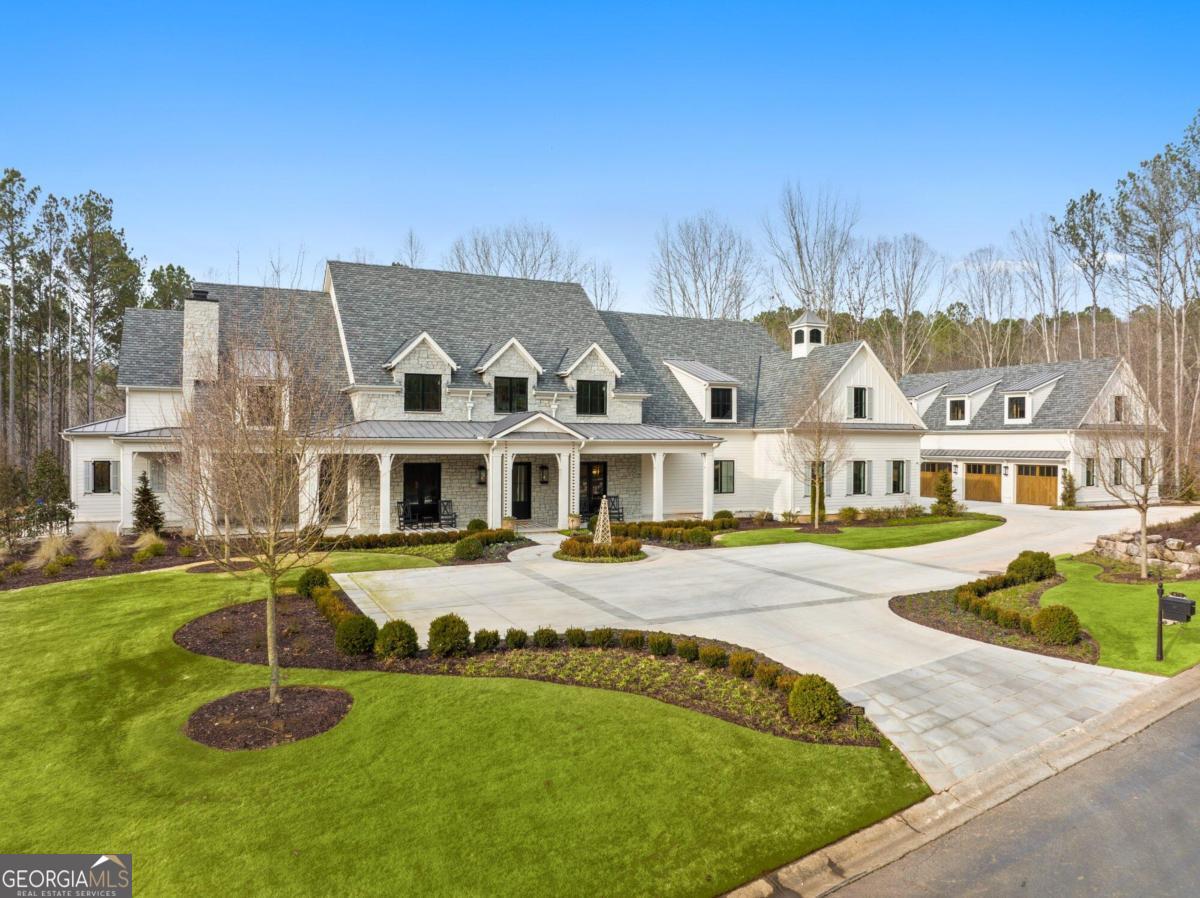 NEW CONSTRUCTION WITHOUT THE WAIT in Hawks Ridge, Georgia's premier golf club community. As you approach this home, perched on 5 acres deep in the neighborhood, youare greeted by a circular drive and a front porch that beckons you in for a glass of iced tea. Out back youall want to relax by the zero-entry, saltwater Pebbletec pool and spa with a built-in cover, surrounded by a rare flagstone and fire bowls for evening drama. Step inside and soak in the light-filled spaces accented by a neutral color palette on the walls and white oak, monocoat flooring. Custom details and designer flourishes are found throughout as you would expect in a home of this caliber. The kitchen is well-suited to everything from a catered affair for a hundred guests to a casual family buffet. An eye-catching zinc hood sits above a 6-burner Wolf stove with a built-in griddle and 2 ovens. Along the adjoining wall are a full-size Subzero refrigerator and freezer separated by a wine chiller. Of course, the centerpiece of the room is two oversized islands topped by quartzite counters. Hidden behind an ordinary cabinet door is a butleras pantry housing an additional refrigerator, a Miele coffee maker, a pebbled-ice ice maker, and copious storage. The kitchen also offers a causal eating area highlighted by a wood-clad coffered ceiling and pool views. Separating the kitchen and great room is a double-sided stone fireplace. The great room has soaring ceilings with wood beams that keep the room feeling light and airy. There is abundant wall space throughout the home, particularly in the great room, ideal for displaying your carefully curated art collection. Just beyond the great room is the primary suite featuring a vaulted ceiling, pool views, ensuite bath, beverage area, and 2 walk-in closets with custom-built organizers. The primary bath offers the ultimate opportunity to pamper yourself with an MTI bubbler soaking tub, a shower built for two, separate vanities with marble counters, marble floor and an oversized linen closet. Rounding out the first floor is a banquet-size dining room, private office, guest suite, and laundry room with built-in feeding stations for your 4-legged family members. On the upper level are 3 secondary bedrooms each with walk-in closets with custom organizers, private full bathrooms, as well as an additional laundry room. Also on this level, built over one of TWO 4-CAR GARAGES, is an upstairs family/media/playroom with an adjoining bathroom and bunk room. Each bunk is equipped with a charging station and light. There is room to expand over the second 4-car garage should you be in need of an au pair or in-law apartment. In addition to 2 garages, there is a 3rd outbuilding at the end of the driveway with an all-glass garage door that currently houses a workout space but would also be a wonderful home office. On the terrace level are a bar, media room, rec space - complete with full-swing pro edition golf simulator with kid's game and sports package, craft room, guest bedroom, two full bathrooms, and plenty of storage. Outside, when youare done swimming, lounge on one of the patios, on the screened-in porch, or in front of one of the 2 outdoor fireplaces. Hawks Ridge is known for luxurious homes on multiple-acre lots with gated access. Community amenities include a lake, tennis courts, pool, clubhouse, guest cottages, helicopter pad and of course, a Bob Cupp-designed golf course ranked among the top 50 golf courses in the country. People from around the globe fly in to play on one of the nation's premier golf courses. You'll feel a million miles away yet you are close to downtown Milton, Ball Ground, Cumming, and Alpharetta.