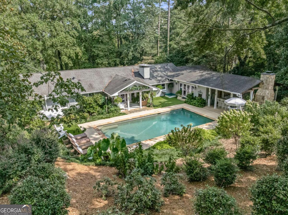 Step into your own private oasis with a sparkling heated PebbleTec pool, complete with a covered outdoor kitchen, bar, built-in grills, and a cozy fireplace - perfect for entertaining year-round. The beautiful landscaping provides privacy in both the front and back yards. Inside, enjoy the ease of one-level living. The bright, renovated white kitchen with a butler's pantry flows beautifully into spacious living and dining areas, opening to a warm family room with windows overlooking the peaceful outdoors. The luxurious owner's retreat offers a spa-inspired oversized shower and a dream-worthy custom closet. There is also another spacious bedroom on main and a full bath in the hall. The finished basement expands your lifestyle options with a full bath and flexible spaces, currently set up as a guest bedroom, workout room, office, and plenty of storage. This home truly has it all - privacy, comfort, and every amenity you need to embrace life to the fullest!