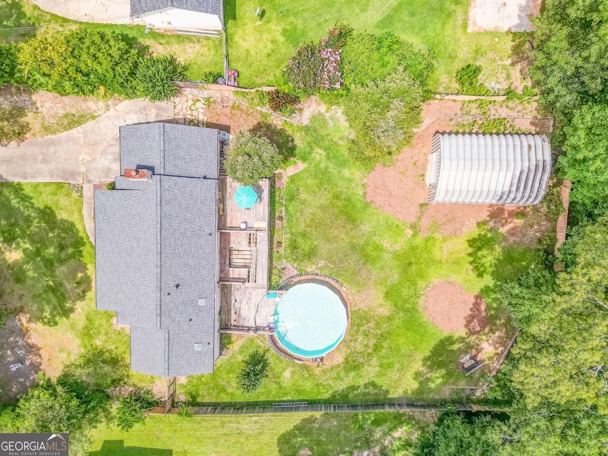 Welcome home to this inviting 3 bedroom, 2 bath ranch perfectly located just off Dallas Highway. This property offers a spacious and functional layout ideal for comfortable living and entertaining. Step into the large Great Room featuring a striking stone fireplace with gas starter, perfect for cozy evenings. The roomy eat-in kitchen includes a breakfast bar and abundant storage, making meal prep and gatherings a breeze. The bathrooms have been freshly updated and are stylish and sleek. Enjoy summer days on the expansive 3-tier deck or take a dip in the above-ground pool. The screened front porch provides a perfect spot to relax, while the oversized backyard features both a standard outbuilding for yard tools and an extra-large outbuilding offering endless possibilities workshop, storage, or hobby space. Additional features include a large single-car garage with added storage space and a location that can't be beat just minutes from shopping, dining, schools, and all the conveniences of Dallas Hwy. Located just past Walmart in a quiet neighborhood, this home offers the perfect blend of comfort and convenience. Don't miss this opportunity schedule your showing today!