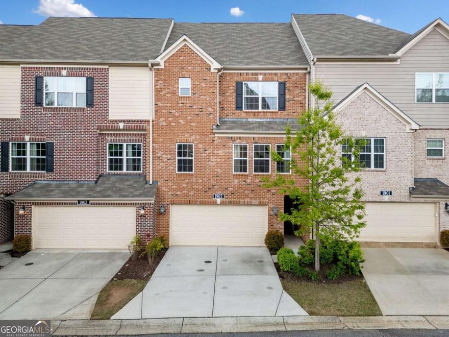 Welcome Home to Glen Ivy! Where Convenience Meets Charm!    Located just minutes from Marietta Square and with easy access to I-75, this beautiful newer townhome in Glen Ivy's gated community offers a perfect balance of comfort, style, and convenience.    The main level includes a spacious guest suite or flex area. It features an en-suite bathroom and has private access to the patio and yard via lovely French doors. This versatile room can serve as a guest retreat, home office, playroom, or hobby space.    Upstairs, you'll find a bright and airy open layout with 9-foot ceilings and hardwood floors throughout the main living areas. The cozy living room opens up to a large deck. It provides peaceful wooded views, ideal for relaxing or entertaining. The kitchen shines with its white cabinets and granite countertops. It has stainless steel appliances and an open concept. A breakfast bar offers extra seating, while the roomy dining area is perfect for hosting friends or enjoying a quiet meal.    The upper level is home to a relaxing primary suite, complete with tray ceilings, a walk-in closet, and a spa-inspired bathroom featuring dual vanities, a soaking tub, and a walk-in shower. An additional spacious bedroom with its own en-suite bathroom completes the upstairs.    Residents of Glen Ivy enjoy access to a pool and dog park, and are just minutes from shops, restaurants, and all the charm of Marietta.    This is the perfect opportunity to experience low-maintenance living in a highly sought-after location. Don't miss out!