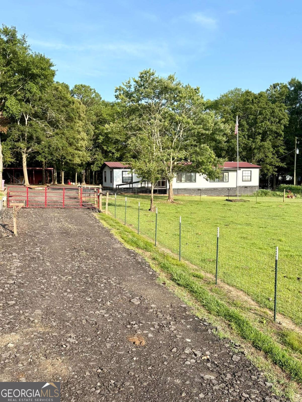 Mini Farm Dream Remodeled Homestead on 5+ Acres! Discover country living at its finest with this versatile mini farm, perfect for self-sufficiency and peaceful rural life. Nestled on over 5 acres of fully fenced land, this beautifully remodeled 4-bedroom, 2-bath double wide offers comfort, charm, and endless potential. The property features a barn with stalls, multiple watering stations for animals, and a camper site already in place ideal for guests or added income. A huge workshop, shed, and additional outbuildings provide ample space for hobbies, storage, or expanding your homestead vision. Cozy up on cold winter nights by the wood-burning stove, and enjoy the freedom of a lifestyle that's truly your own. Whether you're starting a new chapter in country living or looking for the perfect place to grow your roots, this property is ready to bring your homesteading dreams to life! *Property is sold As-Is, no disclosures.