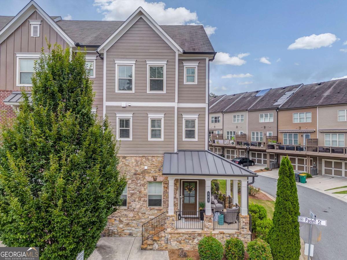 Welcome to Luxury Lifestyle Living in the heart of Downtown Woodstock this end unit at 28 And Mill is only a block from main street! This upscale townhome features 3 well appointed levels, offering about 2,143 sq ft of thoughtfully designed living space. It includes a 2 car rear entry garage and a covered front porch- ideal for greeting neighbors and guests the rear deck is perfect for relaxing or entertaining. Upgrades include but are not limited to wood accented walls creating a modern aesthetic thick rich textures that elevate the entire space. The kitchen flows into the dinning area - then to the living room. High ceilings oversized window, crisp trim detailing amplify the airy open feel. Gourmet kitchen is a delight to the chef in your family with the oversized island extra cabinets and counter tops - double ovens make cooking a breeze! The pantry-laundry-all closets have solid wood shelving built for serious storage. Roommate floor plan with the lower level having a bedroom with a full bathroom suite. Attic plus above garage you will find extra storage space. This home is unapologetically stylish every surface is refined not your ordinary home. This is the kind of home that whispers I know what I'm doing and shouts make an OFFER!!! Perfect for the smart classy functional mind set with ZERO fluff!