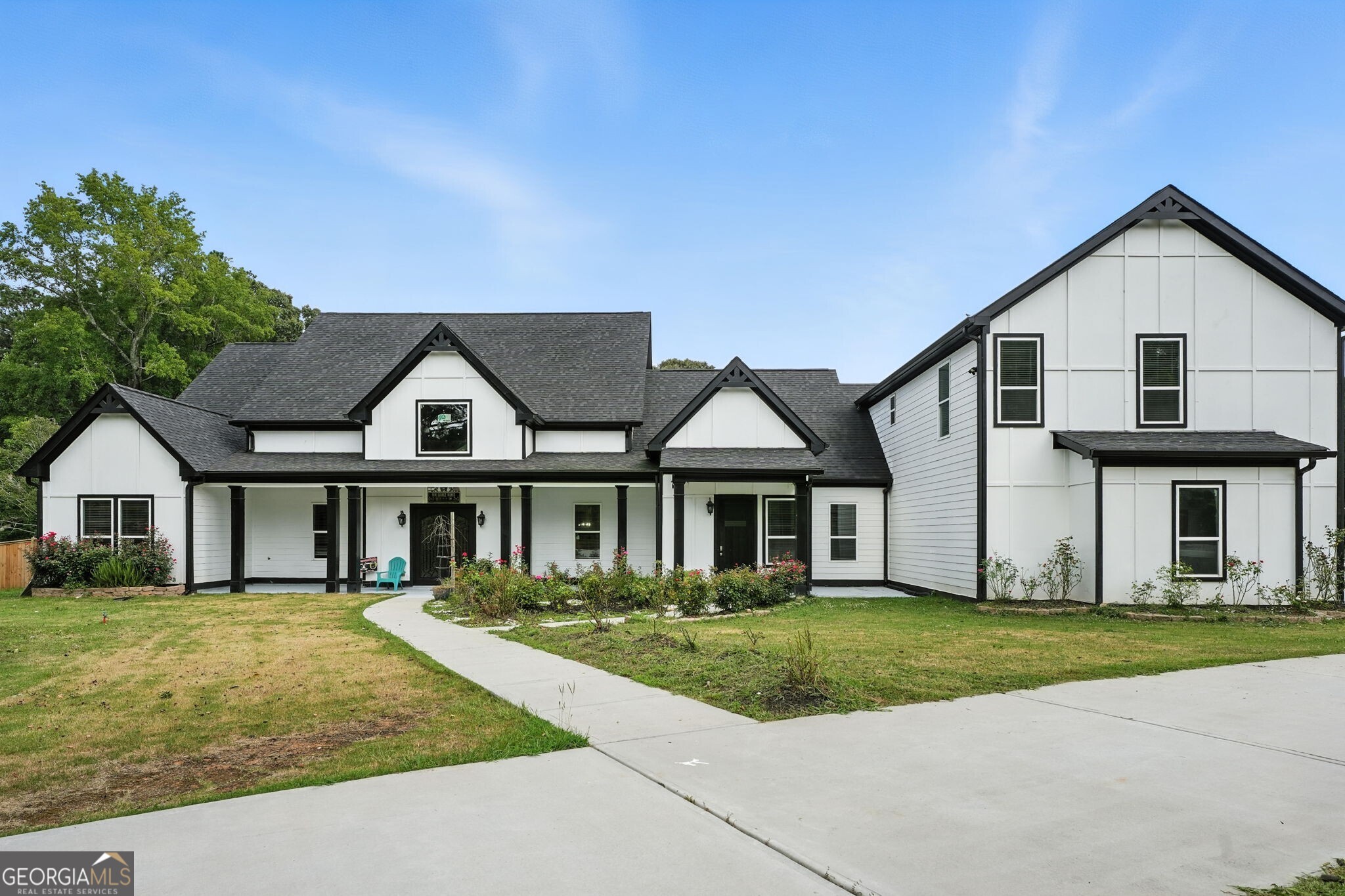 Welcome to this stunning modern farmhouse offering the perfect blend of elegance, space, and functionality. With a total of 6 bedrooms and 5.5 bathrooms, this thoughtfully designed home provides ample room for multi-generational living or hosting guests in style. The exterior showcases clean lines, a striking black-and-white color scheme, and expansive covered porches that create exceptional curb appeal. Inside, you'll find a bright, open-concept layout with gleaming marble-style porcelain floors, soaring ceilings, and upscale finishes throughout. The heart of the home is the gourmet kitchen featuring custom gray shaker cabinetry, quartz countertops, a massive center island with bar seating, stainless steel appliances, and a sleek vent hood. Seamless flow connects the kitchen to the dining area and spacious living room with coffered ceilings, perfect for both entertaining and everyday living. The luxurious primary suite features a spa-inspired bath with an oversized walk-in shower, dual vanities, and built-in shelving. Additional main-level bedrooms are generously sized and filled with natural light. Upstairs, a private apartment offers 2 bedrooms, 1 full bathroom, full kitichen and a laundry, a living area, and separate access ideal for extended family, guests, or rental income potential. The home also includes a 3-car garage, wide driveway, and a private upper-level deck overlooking a lush backyard. Conveniently located near schools, shopping, and major highways, this exceptional property delivers the ideal combination of space, style, and versatility.