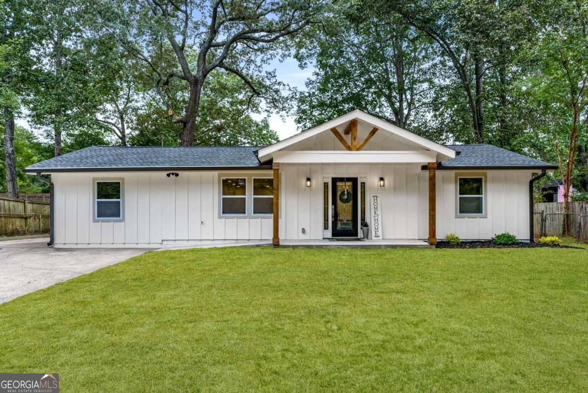 Step inside this fully renovated 4-bedroom, 2-bathroom home in the heart of Smyrna, where modern design meets timeless charm. Every detail has been thoughtfully transformed, starting with the exterior featuring new board-and-batten siding, fresh windows, a welcoming front gable accented with cedar posts, a brand-new roof, and a convenient ramp for easy access. Updated electrical and plumbing bring peace of mind, ensuring this home is as functional as it is beautiful. The heart of the home is the spacious open-concept kitchen designed for both everyday living and entertaining. Showcasing a striking two-tone design, it features a white oak island with quartz countertops, complemented by crisp white cabinetry with brass hardware. A pot filler adds convenience, while the hidden walk-in pantry with custom shelving provides an unexpected touch of luxury. The oversized primary suite offers a true retreat, complete with a spa-like bathroom featuring double vanities, a freestanding soaking tub, and a custom shower with dual showerheads. The walk-in closet includes built-in shelving for effortless organization. Three additional bedrooms share a beautifully updated bathroom, providing comfort for family or guests. Additional highlights include a covered carport, a level fenced backyard with a storage shed, a front-entry ramp, and thoughtful finishes throughout. With all renovations completed, this under-2,000-sq-ft home is move-in ready and designed for today's lifestyle. Located just off South Cobb Drive, you're minutes from grocery stores, parks, and everyday conveniences. The Silver Comet Trail and Smyrna Village are nearby for outdoor recreation and community events, and Downtown Marietta is just a short drive away. Enjoy the perfect combination of a fully renovated home and a central Smyrna location.