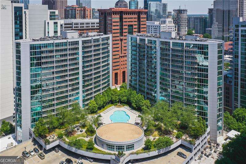 Sitting high on the 19th floor, this beautiful, bright and airy 2-bedroom room mate plan condo is a gorgeous nesting place with western sunset views. From the moment you step inside, you're greeted by a sweeping wall of floor to ceiling windows that floods the space with natural light and offers breathtaking views of Atlanta's skyline. The open floor plan is perfect for both quiet evenings and lively entertaining, with gleaming newer hardwood floors sleek granite countertops, stainless steel appliances along with gorgeous new mint blue subway tile. The entire condo is freshly and brightly painted awaiting your splashes of color. This home includes two covered parking spots right next to the elevators, so nice to get out of the car and walk straight into the building. RARE oversized 5' x 15' storage unit!! Life here comes with every convenience: take a private elevator ride straight to Publix, pick up your dry cleaning, grab a bite at nearby restaurants, take a yoga class or hop on MARTA or 2 minutes and your on the connector. A little over half a mile to Georgia Tech! And when it's time to unwind, enjoy resort-style amenities including an outdoor pool, fitness center, stylish club room. This is way more than a place to live. it's a wonderful city lifestyle